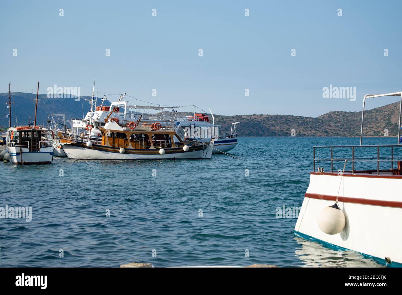 Kleine Freizeitboote vor der Küste der griechischen Insel Kreta, mit der Rückseite eines kleinen Bootes im Vordergrund Stockfoto