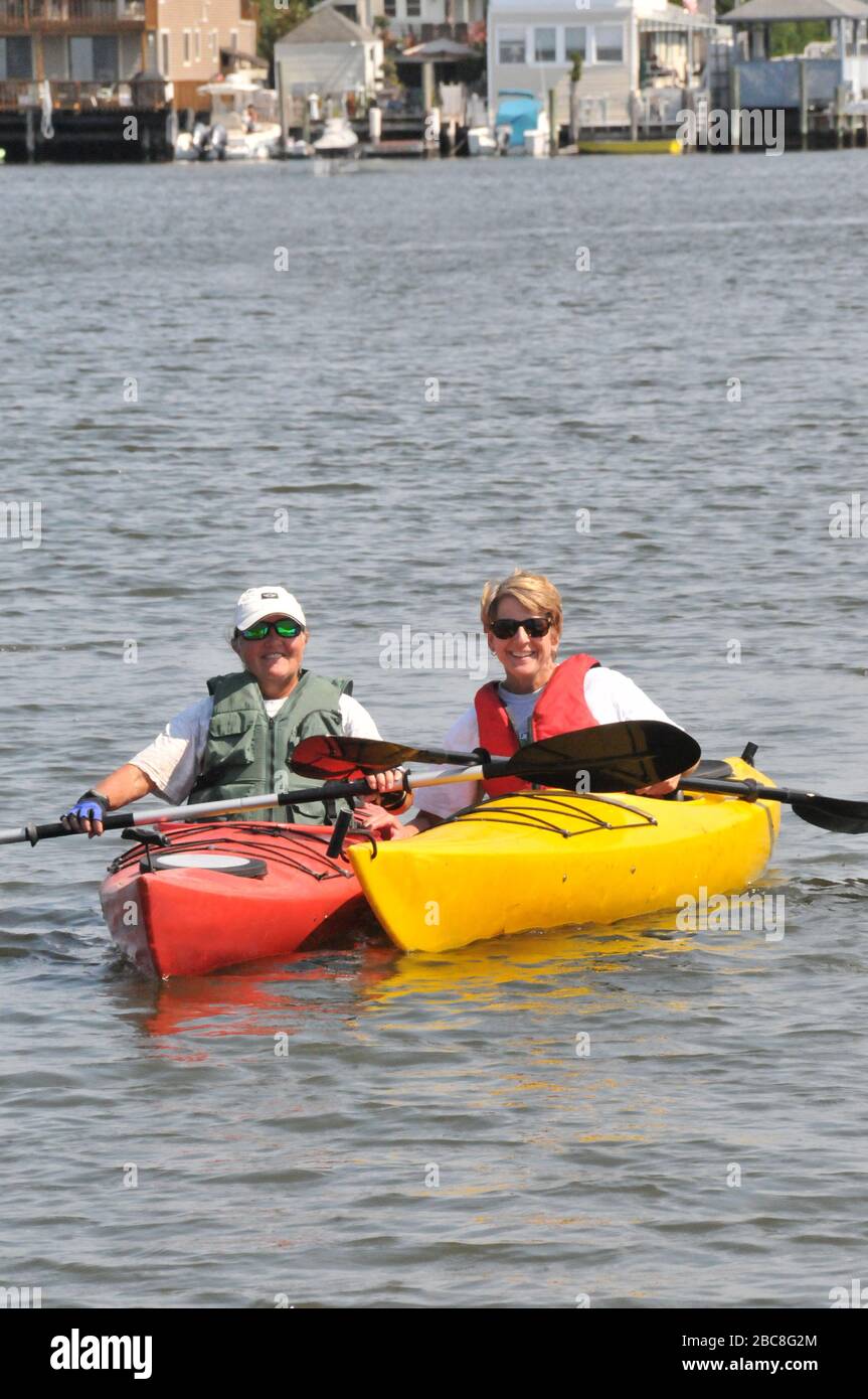 Zwei Erwachsene Frauen auf dem Wasser in ihren Kajaks mit Rettungswesten Stockfoto