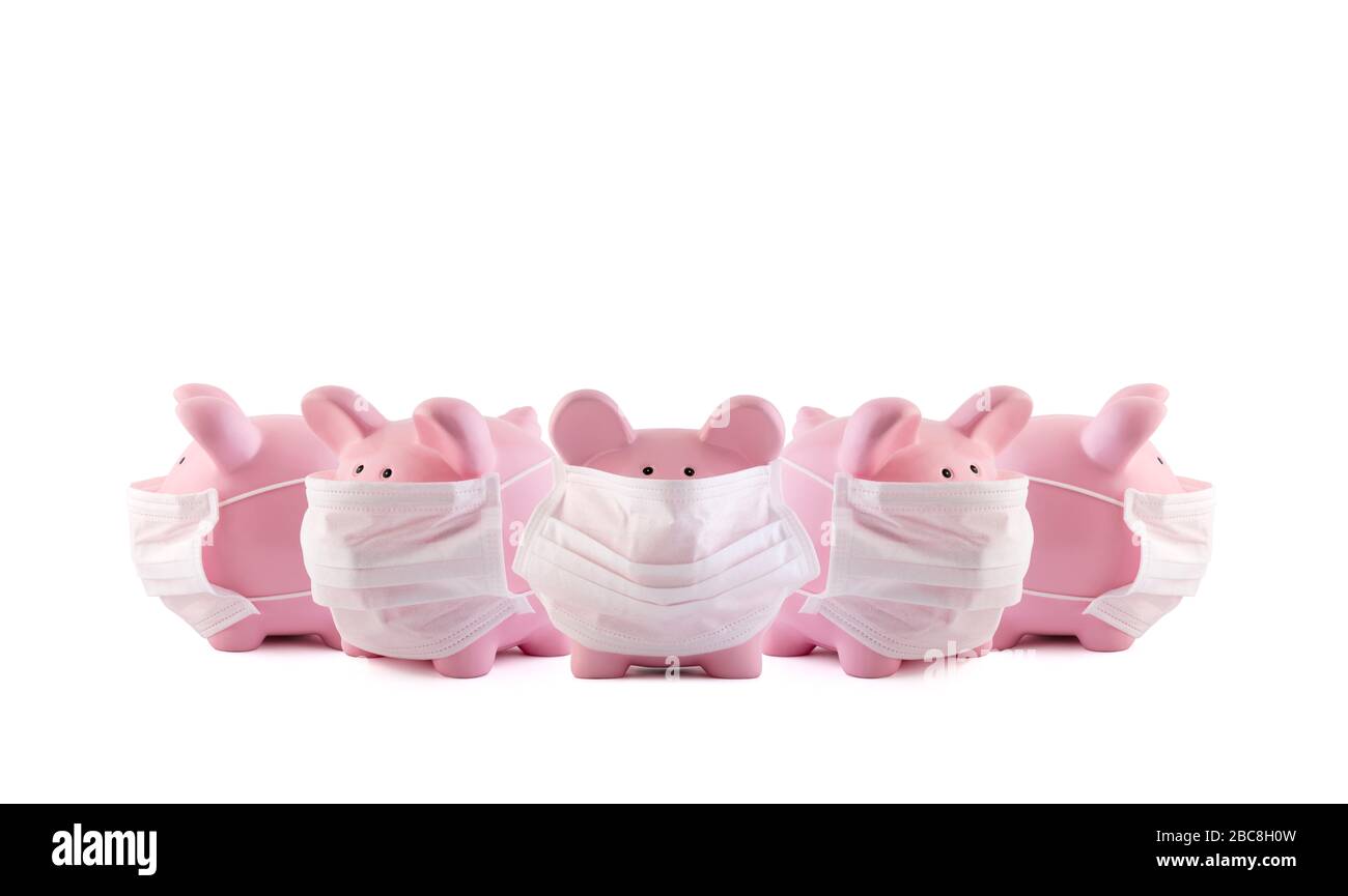 Eine Gruppe pinkfarbener Sparkassen mit medizinischen Schutzmasken auf weißem Hintergrund. Bankgeschäfte während eines Pandemiekonzepts. Stockfoto