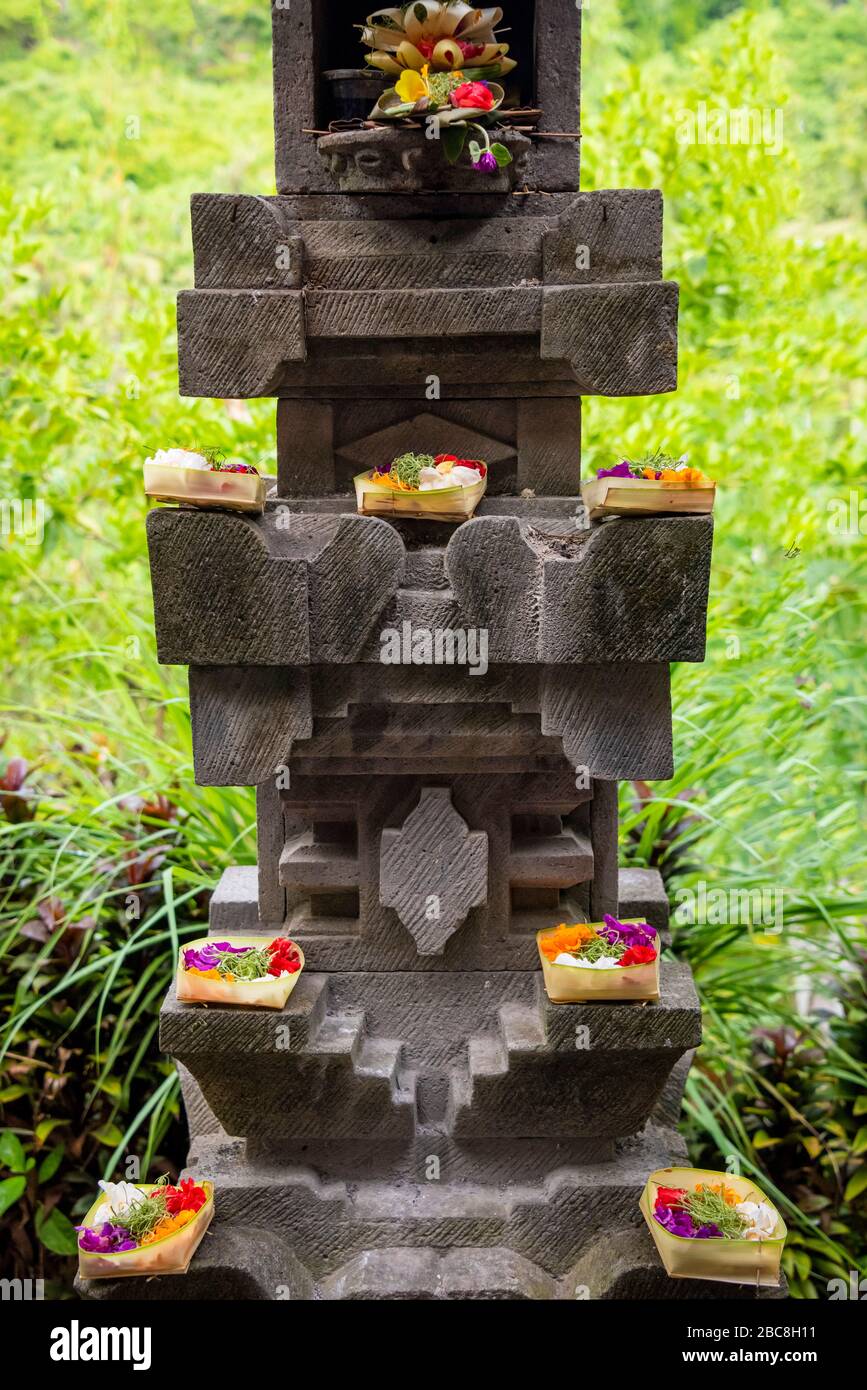 Vertikaler Blick auf hübsche handgefertigte Blumenkörbe, die als Segnungen auf einem Altar in Bali, Indonesien verwendet werden. Stockfoto