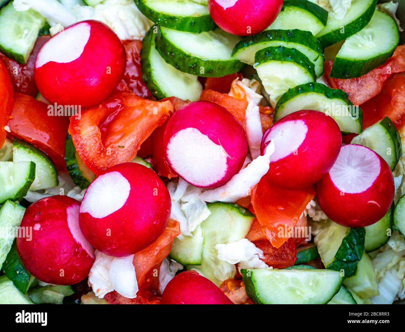 Radistischer Gemüsesalat mit Gurken und Tomaten mit Kohl. Stockfoto