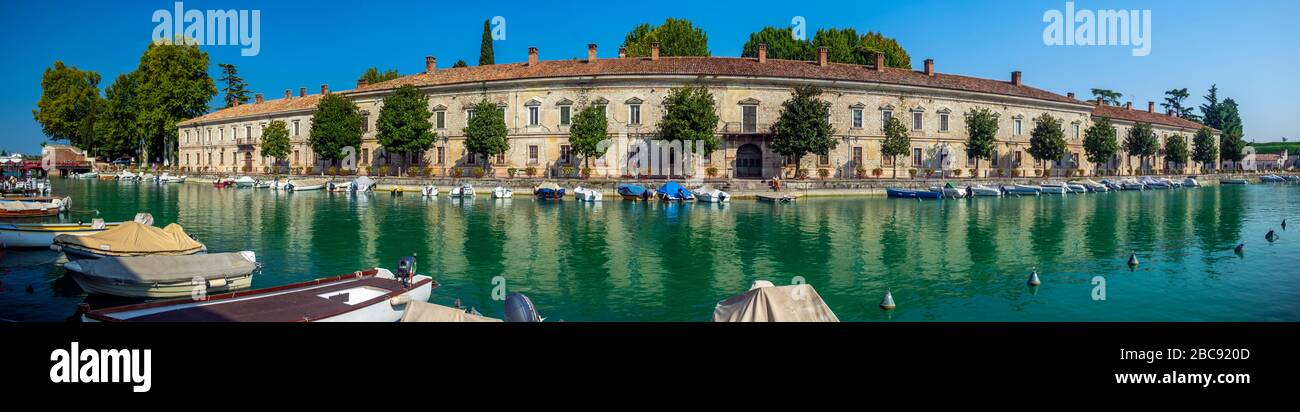 Gardasee mit Häusern, Touristen und Booten in Torbole, Italien Stockfoto