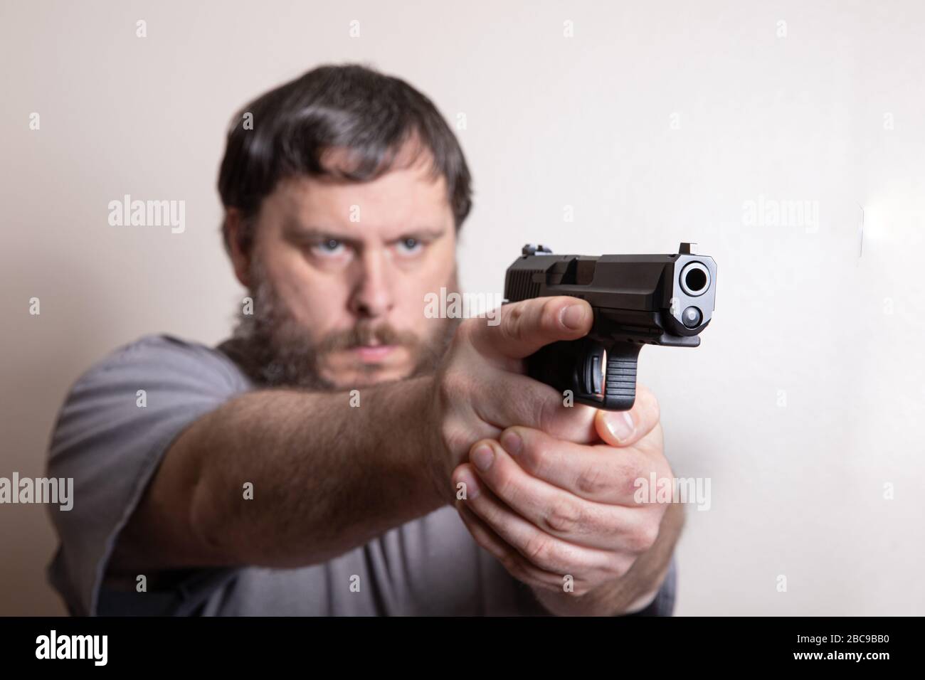 Mann an der Bereitschaftspange, der seine Waffe heraushält Stockfoto
