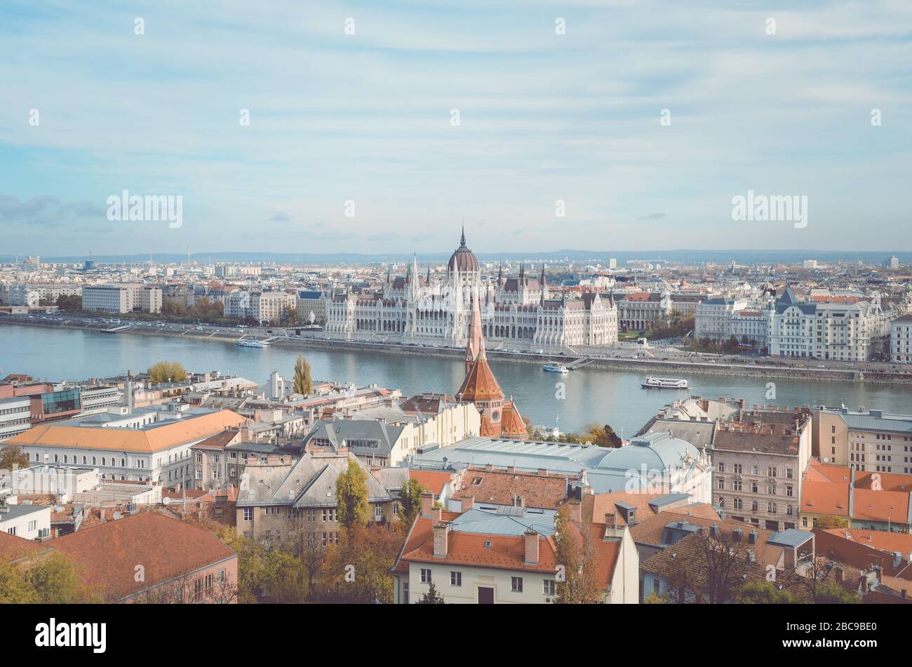 Stadtbild von Budapest, Ungarn. Ungarischer Parlamentsbau, Orszaghaz, im Hintergrund auf der anderen Seite der Donau. Horizontales Foto mit Vintage-Filter. Stockfoto