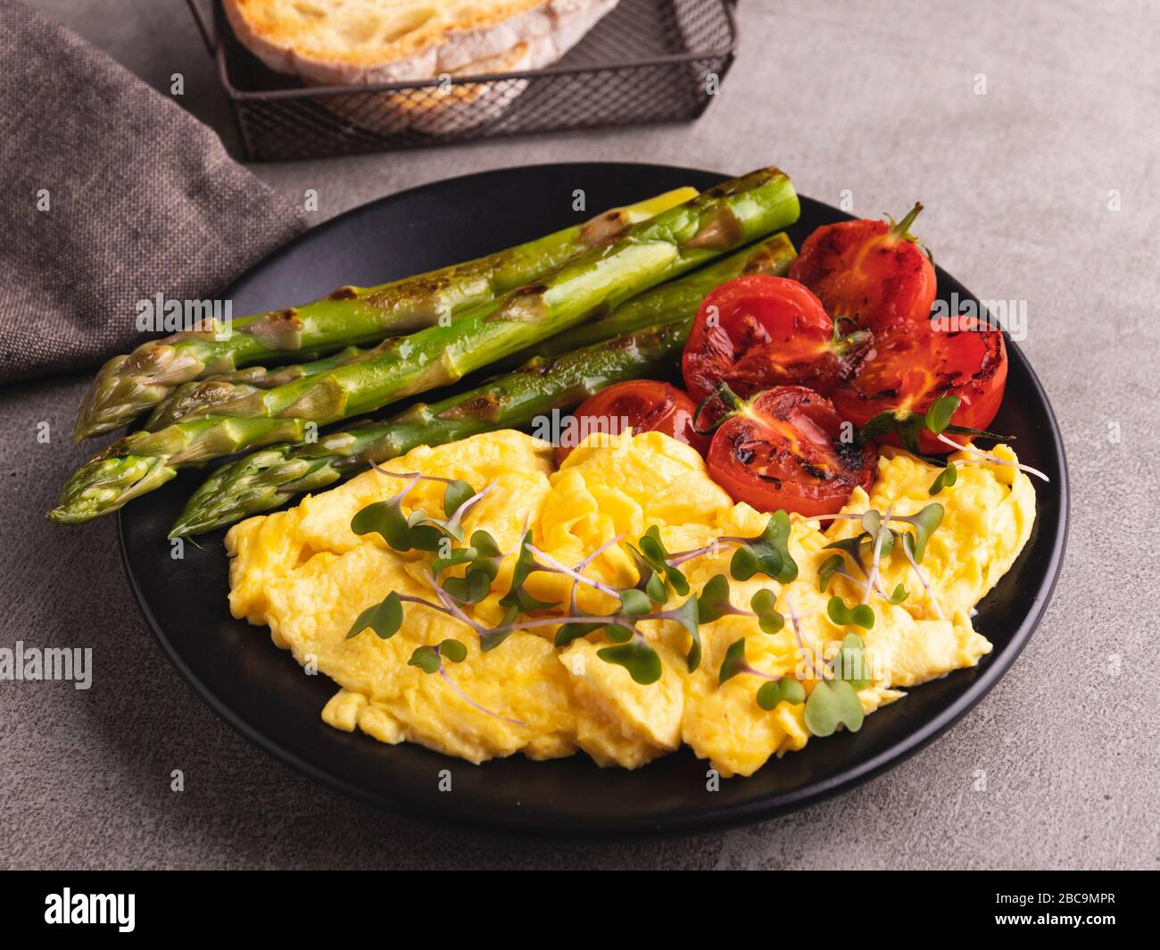 Rührei mit gebratenem Tomatenspargelfrühstück, gesundes Essen Stockfoto