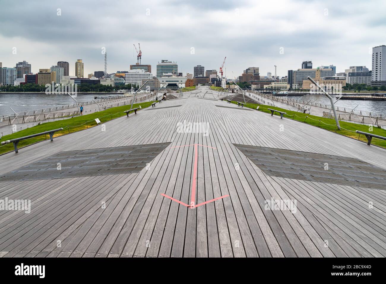 Das malerische Architekturdesign des Yokohama Passenger Terminal (Osanbashi Pier) mit der Skyline der Stadt im Hintergrund, Japan Stockfoto