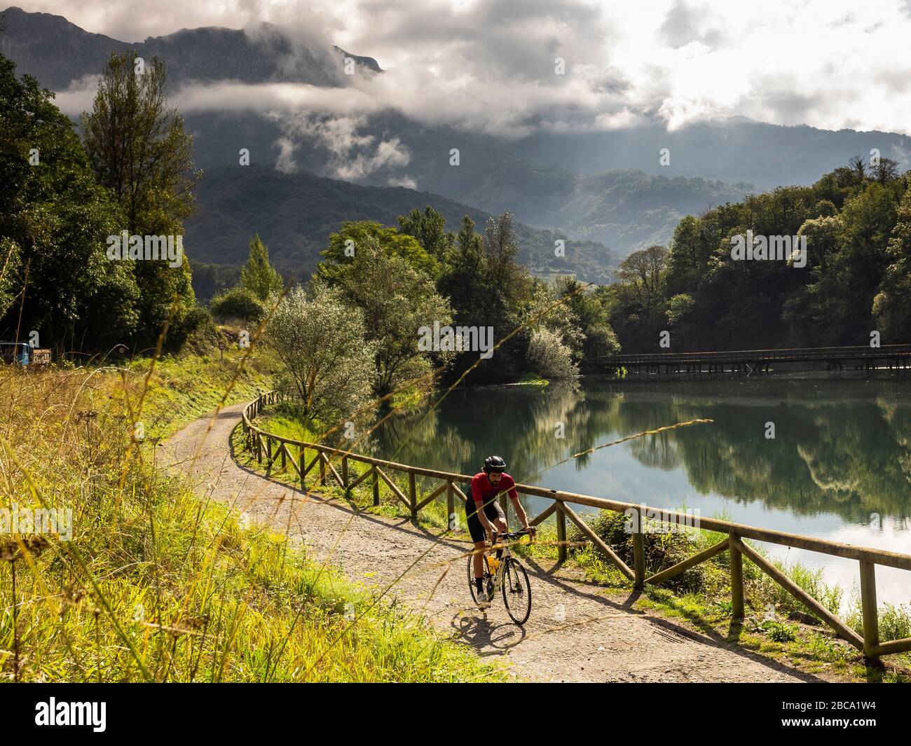 Straßenradsport in Asturien, Nordspanien. Rennradrennfahrer auf dem See "Embalse de Valdemurrio" in den Bergen in der Nähe von Proaza Principado de Asturias, Spa Stockfoto