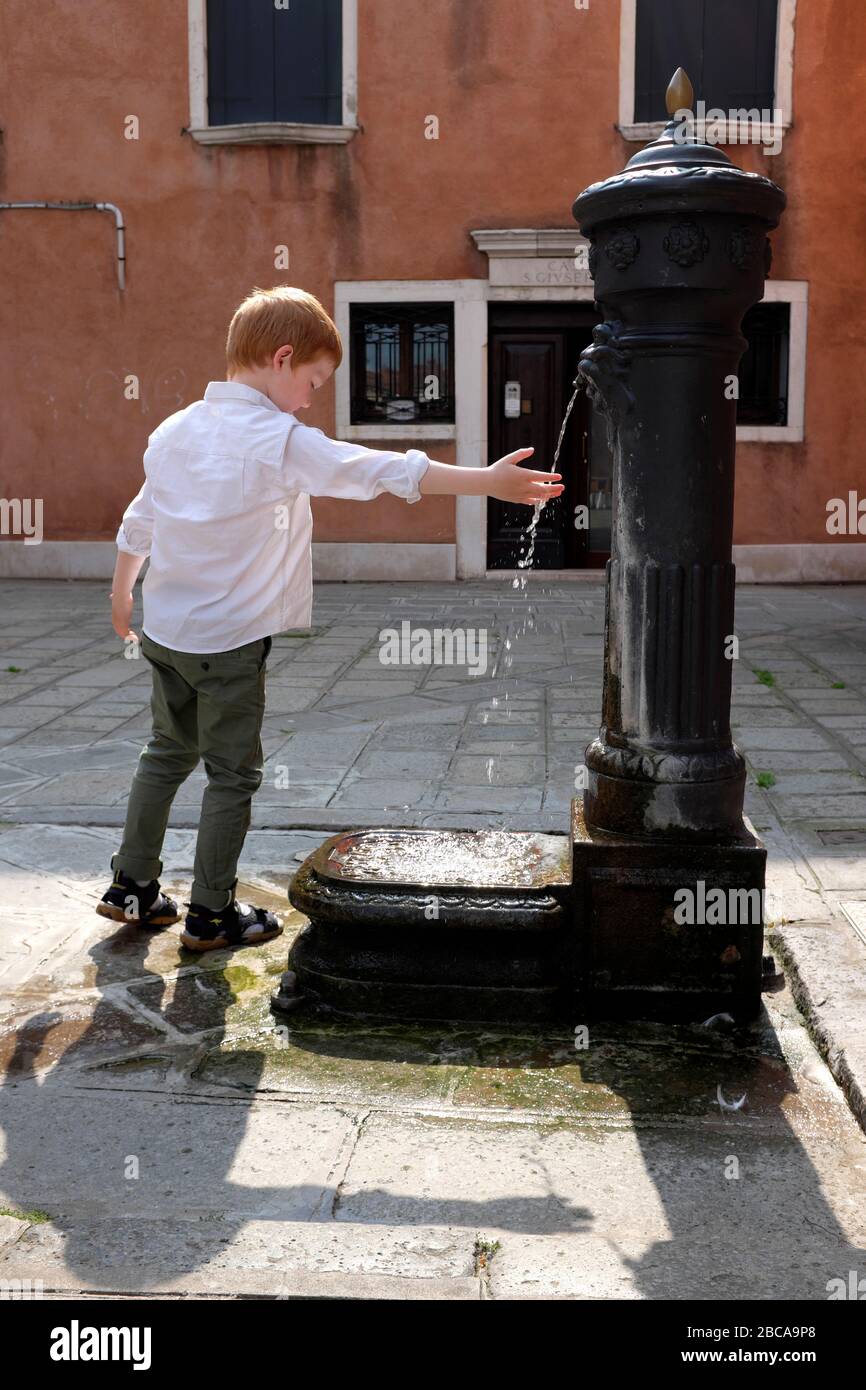 Junge an einem Brunnen in Venedig Stockfoto