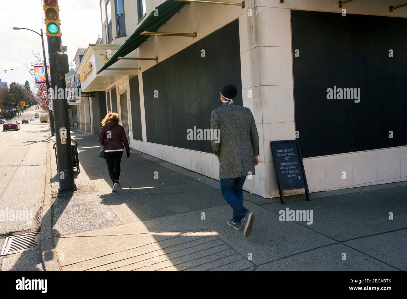 Vancouver, Kanada, 03. April 2020. Die Menschen laufen an Geschäften in der South Granville Street vorbei, die während der COVD-19-Pandemie geentert wurden, um Beutezüge zu verhindern. Stockfoto