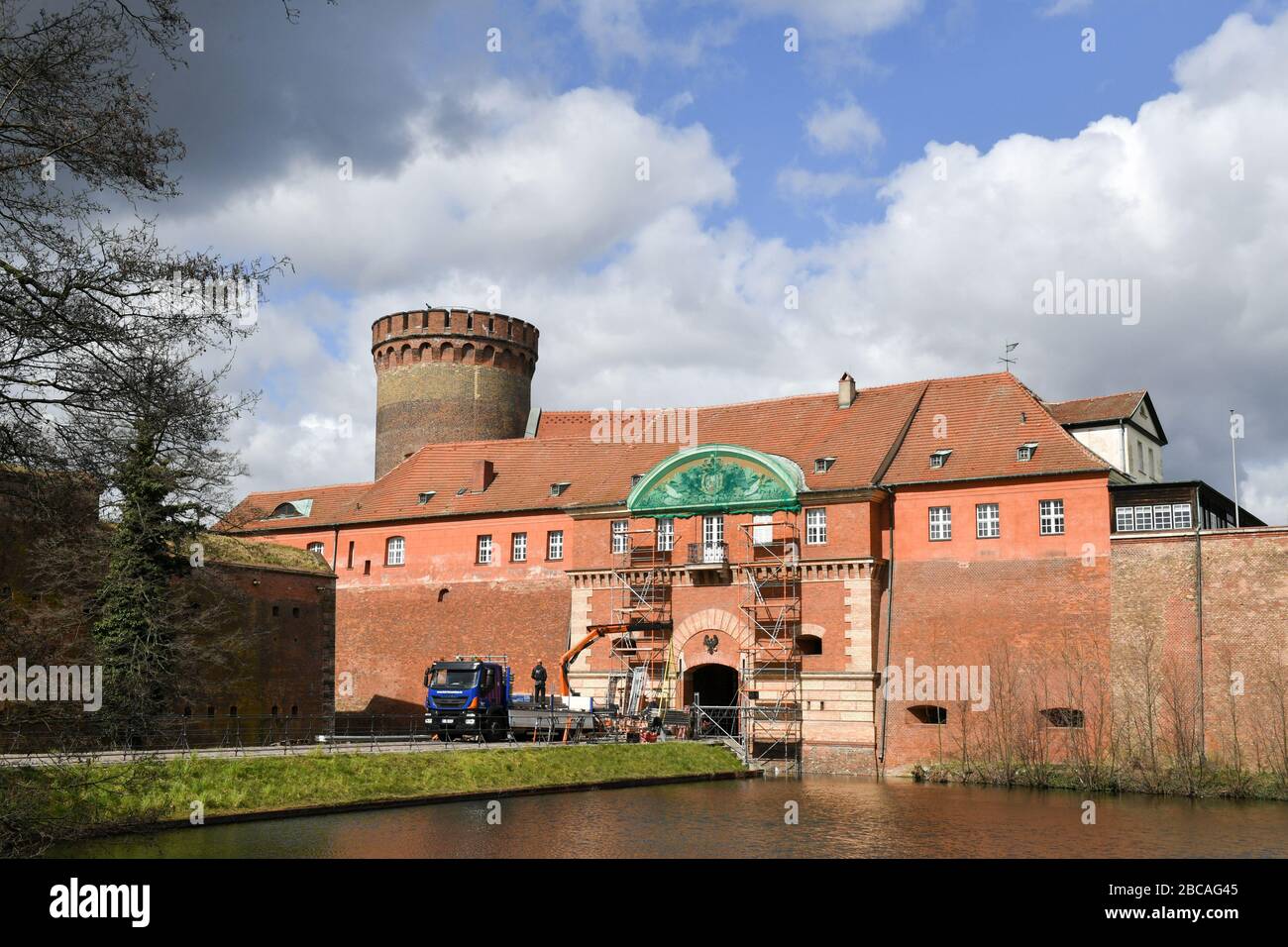 Berlin, Deutschland. April 2020. An der Zitadelle in Berlin-Spandau haben erste Restaurierungsarbeiten am Wappen über dem Eingang begonnen. Die Maßnahmen sind Teil der Umgestaltung der Umgebung und der Wiederherstellung der Zitadelle. Es ist eine der am besten erhaltenen Festungen der Hochrenaissance in Europa. Im Hintergrund ließ der Juliusturm, das älteste Gebäude Berlins vom Anfang des 13. Kredit: Jens Kalaene / dpa-Zentralbild / ZB / dpa / Alamy Live News Stockfoto