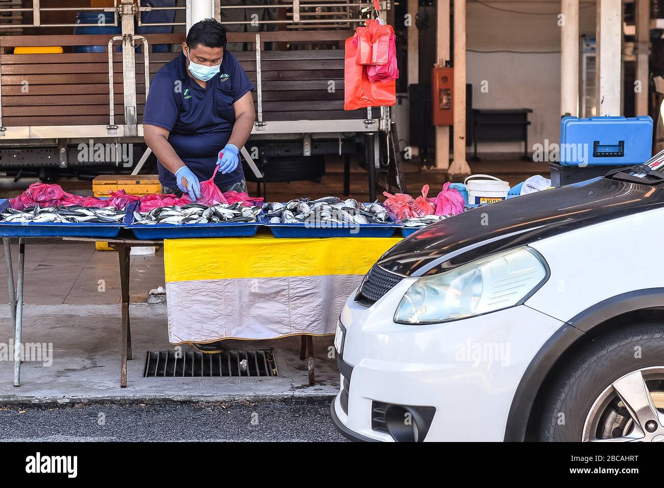 Seremban, Negeri Sembilan, MALAYSIA. April 2020. Ein Auto fährt an einem Fischhändler auf einem Bauernmarkt in Seremban, Malaysia, vorbei. Die Regierung von Malaysia hat am 18. März einen Befehl zur Bewegungskontrolle zur Bekämpfung der Verbreitung von COVID-19 erlassen, in dem nur wesentliche Dienste für den Betrieb zugelassen sind. Kredit: Fuad Nizam/ZUMA Wire/Alamy Live News Stockfoto