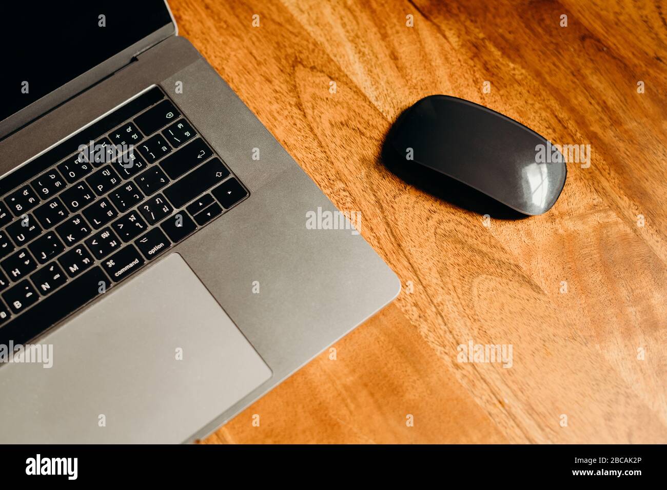 Ein Laptop auf einem Holztisch im dunklen Bereich. Draufsicht. Stockfoto