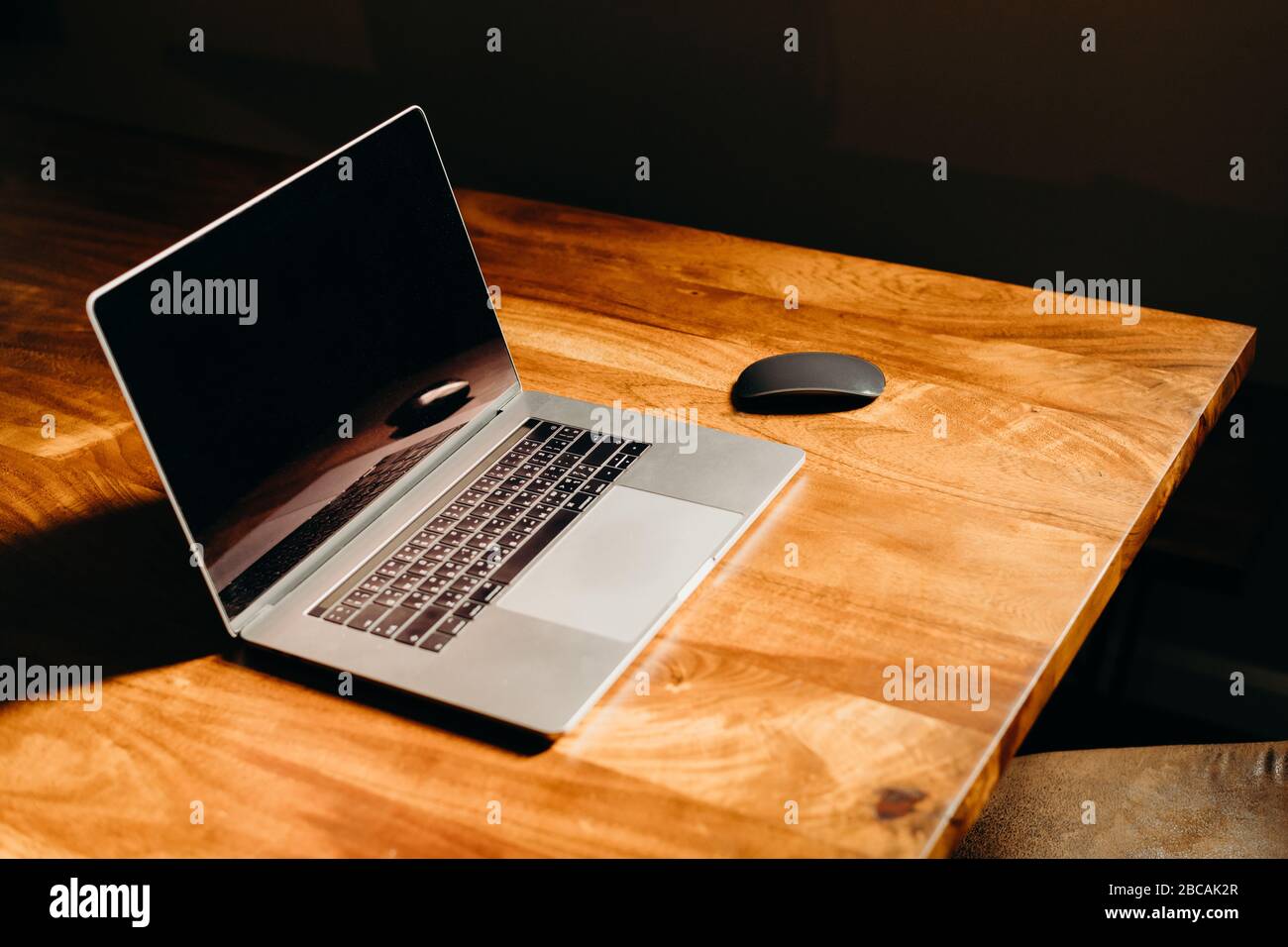 Ein Laptop auf einem Holztisch im dunklen Bereich. Draufsicht. Stockfoto