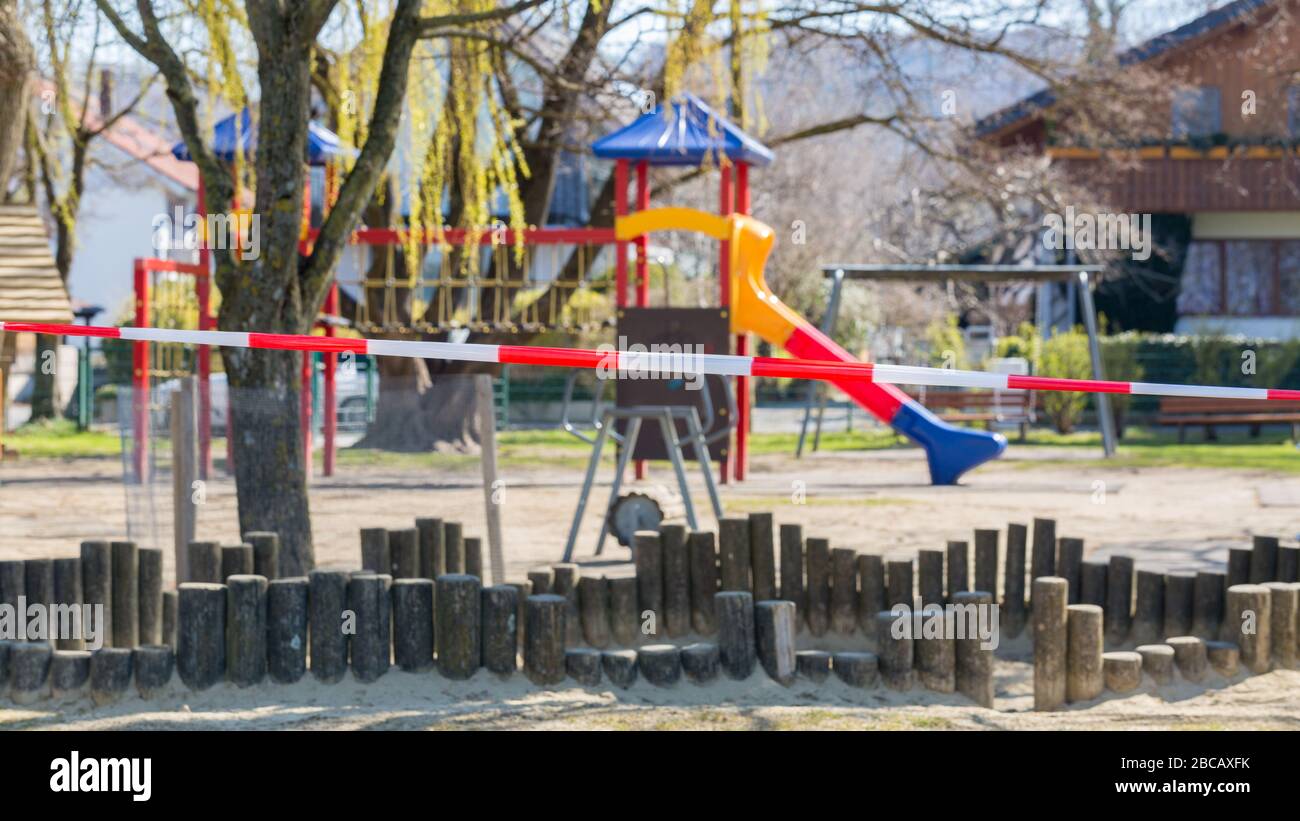 Spielplatz ohne Kinder. Mit einem rot-weiß gestreiften Absperrband verschlossen. Aufgrund der Einschränkungen des Coronavirus (Covid-19) darf nicht betreten werden. Stockfoto