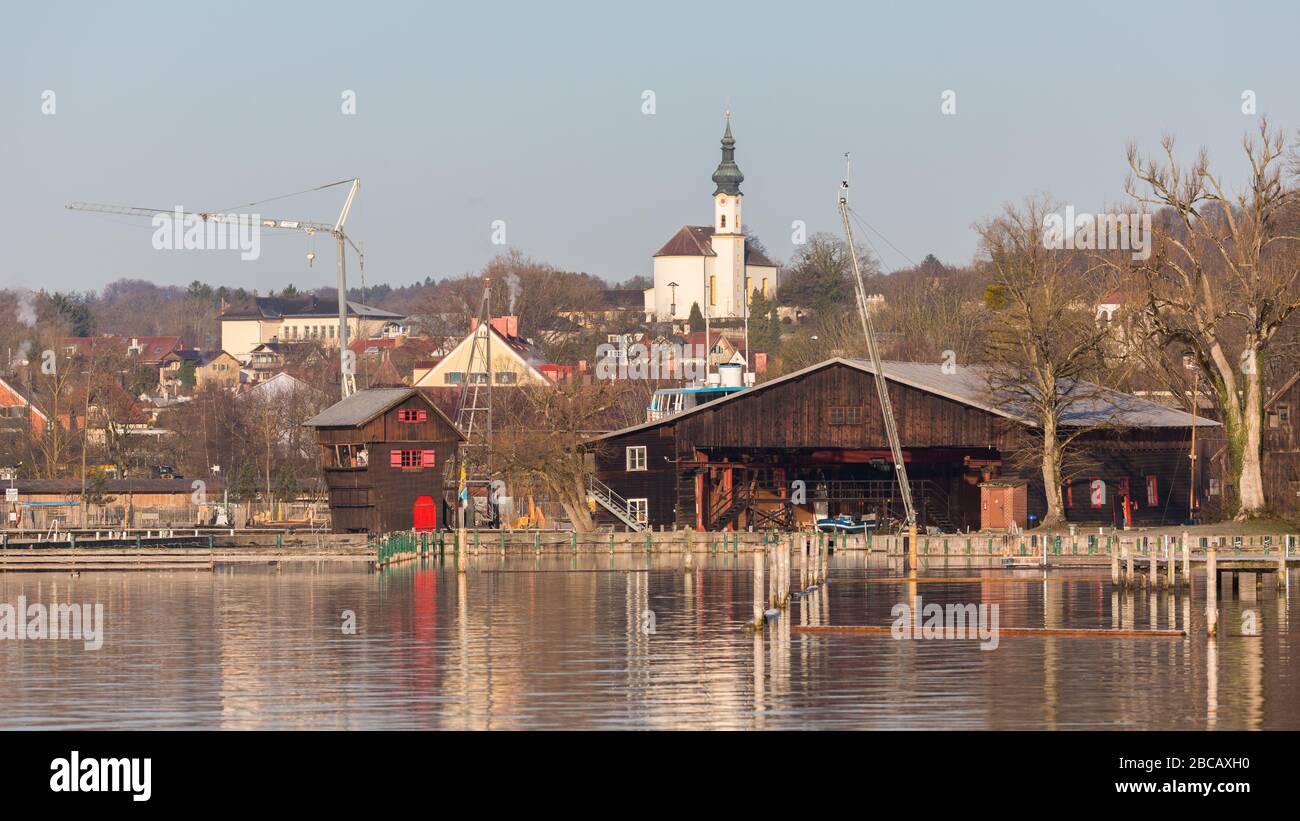 Stadtbild von Starnberg. Mit der St.-Josefs-Kirche im Hintergrund. Die Gebäude im Vordergrund gehören zum Jachthafen. 16:9 Panoramaformat. Stockfoto