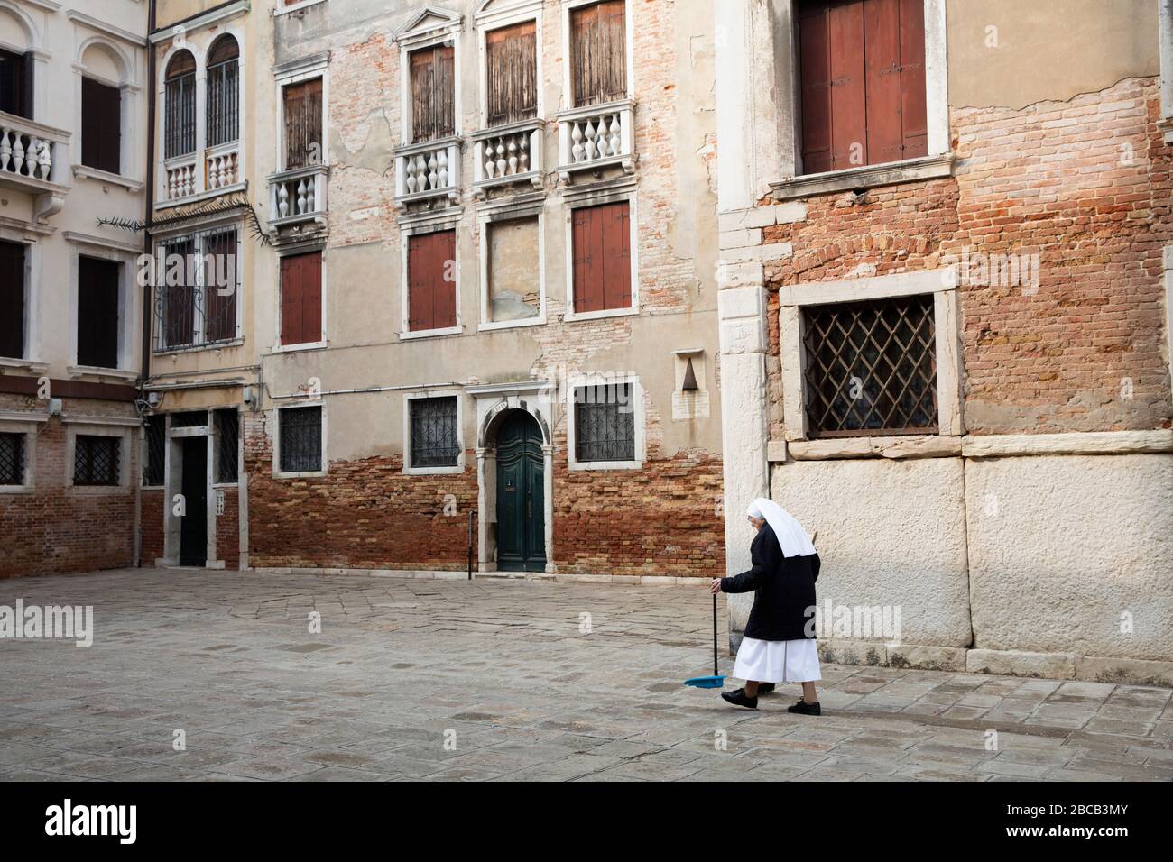 Venedig, Kloster, Nonne fegt den Boden Stockfoto