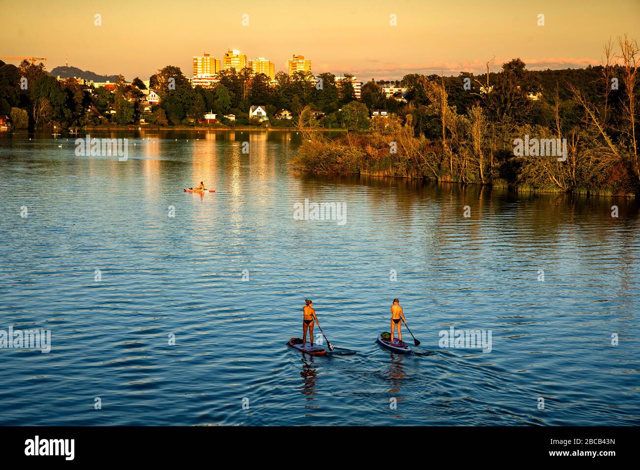 Zwei Frauen genießen die Abendstimmung auf der SUP am Wohlensee bei Bern. Stockfoto