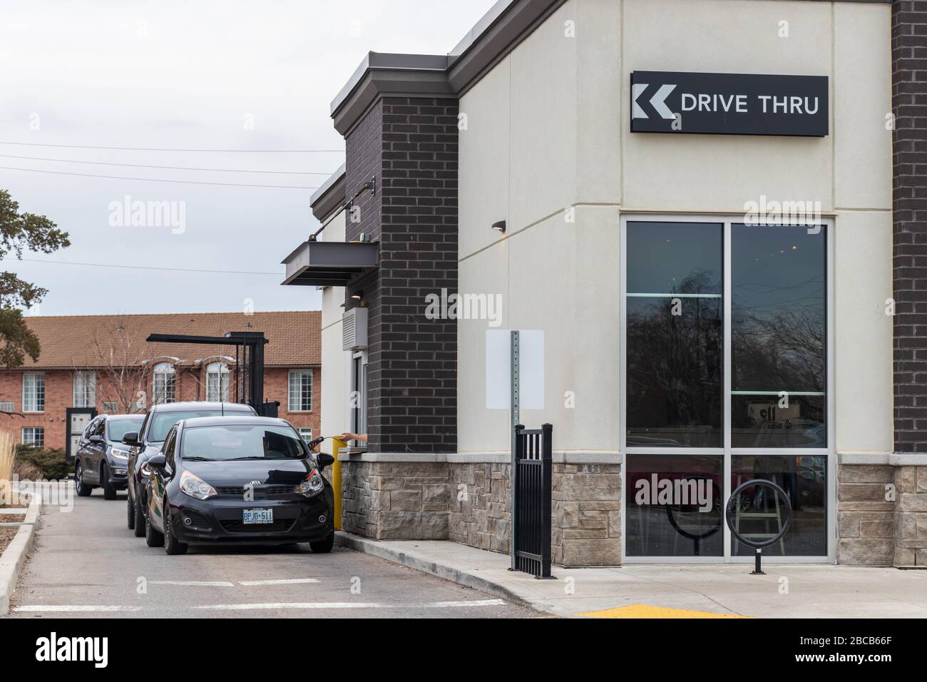 Fahrzeuge im Drive-Thru an einem Starbucks Coffee Standort mit Drive-Thru-Abholung nur aufgrund der anhaltenden COVID-19-Pandemie. Stockfoto