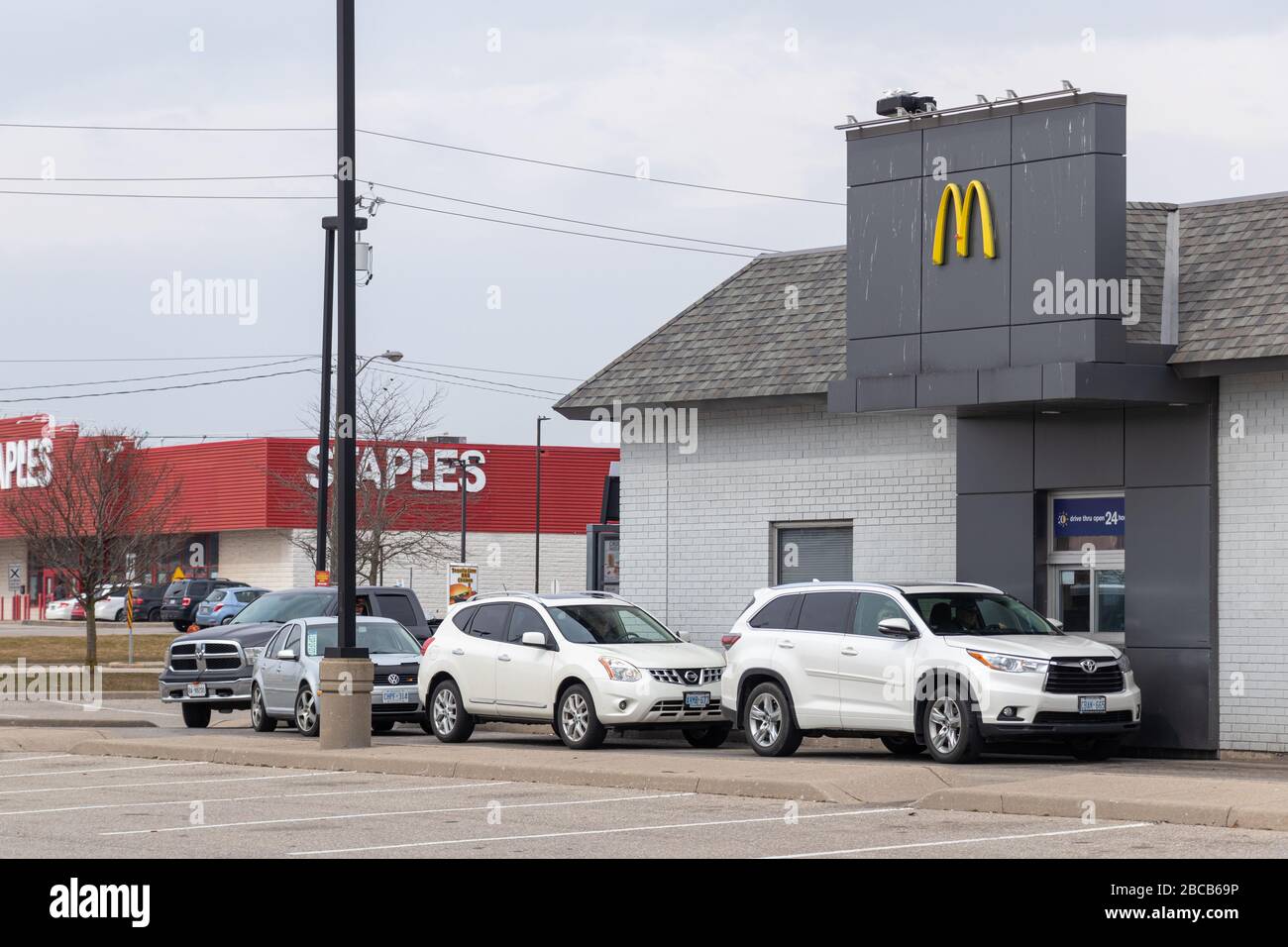 Vehicles in-line at McDonalds drive thru, one car at the pick-up window. Stockfoto