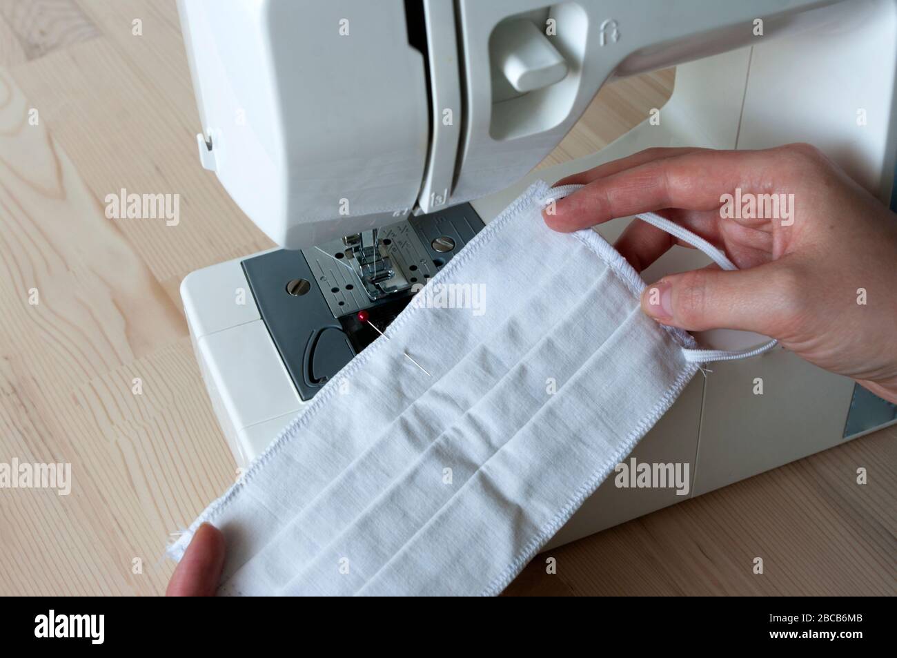 Weibliche Nähmaske zu Hause. Hände, Making Maske mit Nähmaschine. Schützen Sie sich vor Coronavirus. Allergie Stockfoto