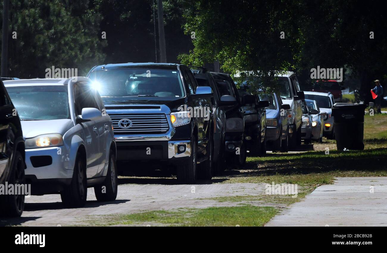 Eine Reihe von Autos steht wieder auf, als die Menschen ankommen, um Lebensmittel von der Second Harvest Food Bank of Central Florida bei einem Drive-Through-Event für bedürftige Familien im Faith Neighborhood Center in der Nähe von Orlando abzuholen. Die Coronavirus Pandemie hat Tausende von lokalen Servicemitarbeitern und Angestellten des Freizeitparks außer Arbeit gesetzt und belastet die Lebensmittelbanken in der Region. Stockfoto