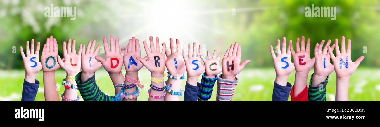 Kinder Hände Halten Wort Solidarisch Sein Bedeuten Solidarität Zeigen, Grass Meadow Stockfoto