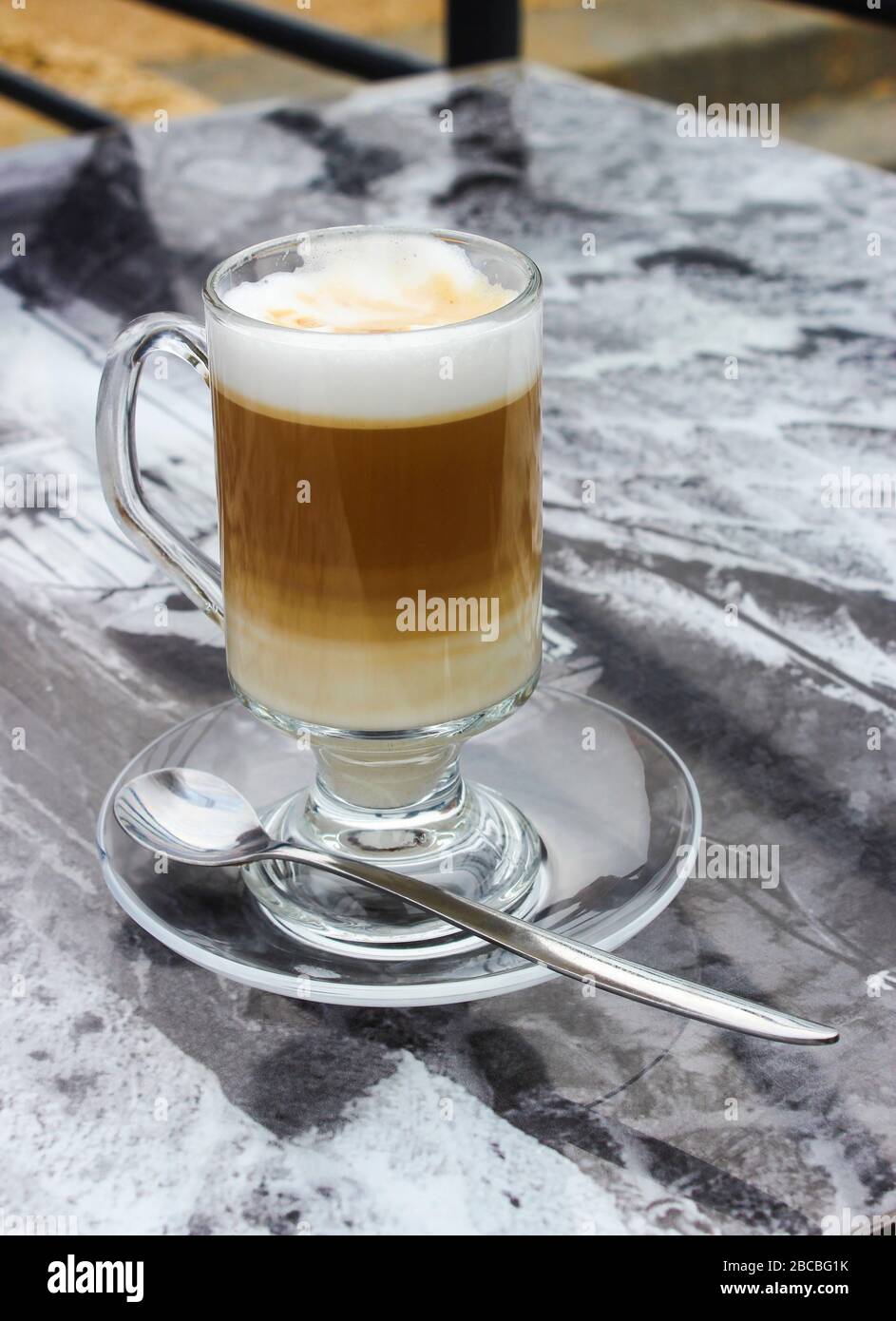 Kaffee mit Milch in einer Glasbecher auf dem Tisch Stockfoto