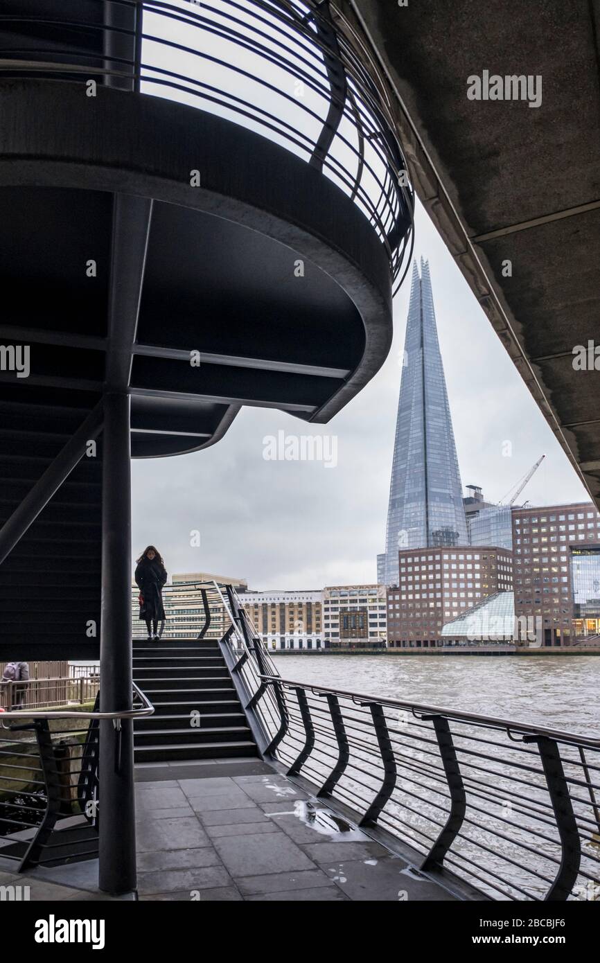 Eine Frau auf einer Treppe zur London Bridge, die eine Verbindung zwischen London Bridge und dem North Bank Riverside Walkway, London, England, UK, bietet Stockfoto