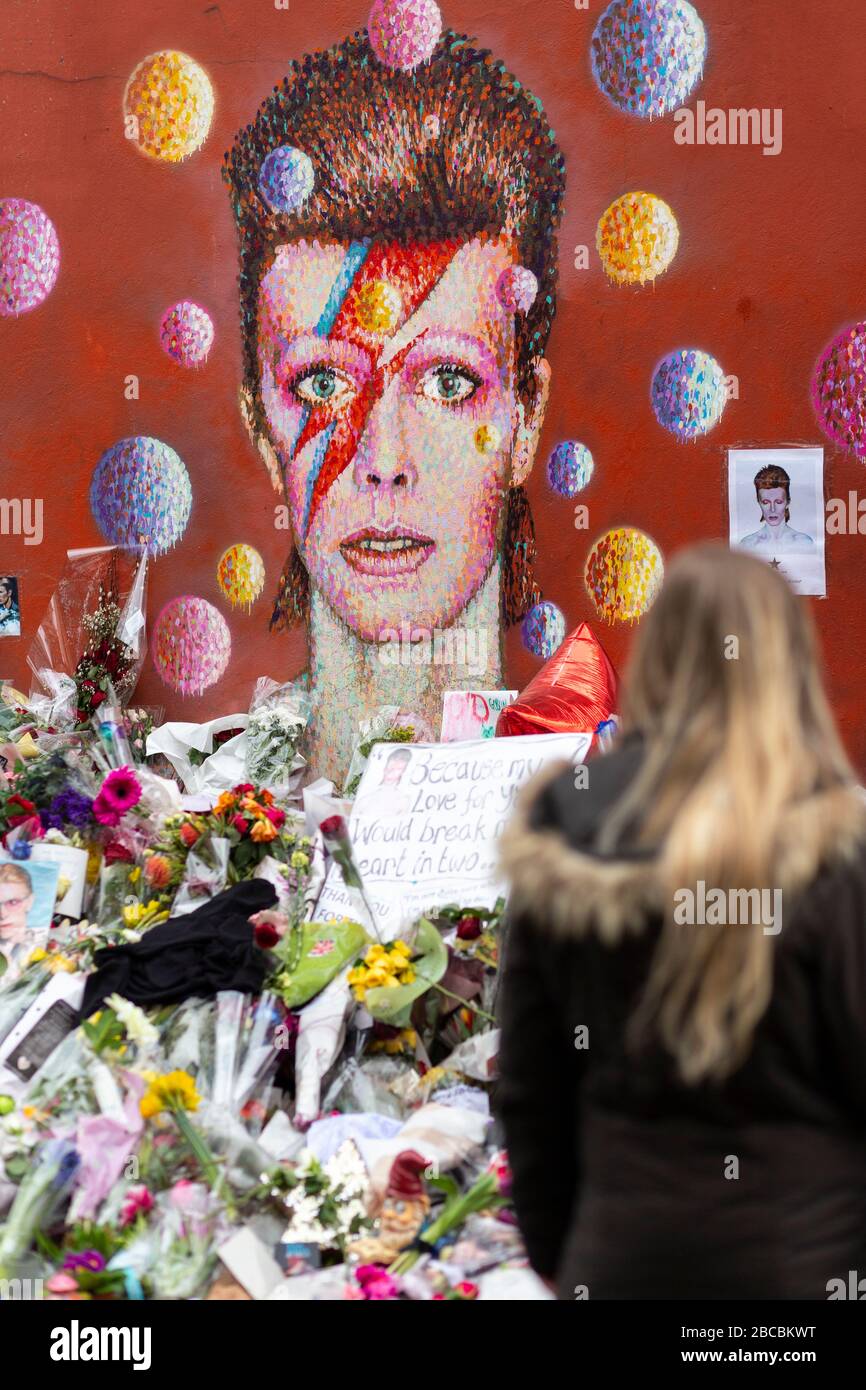 Wandgemälde von David Bowie in Brixton umgeben von Gedenkopfern, die unmittelbar nach seinem Tod in London gelegt wurden Stockfoto