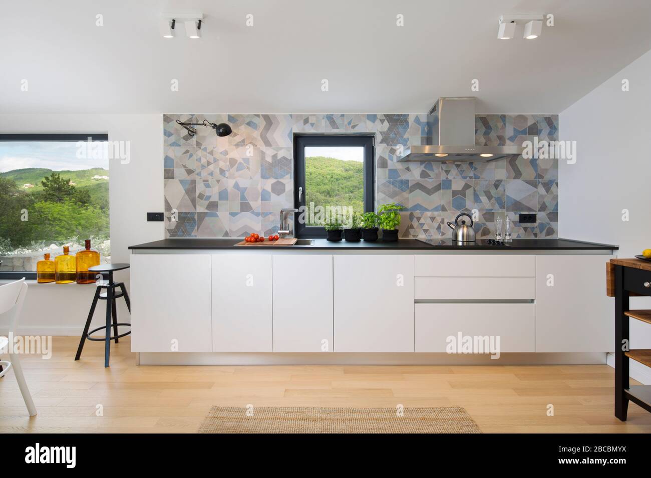 Weiße moderne Küche mit abstraktem Hintergrund und Holzboden. Stockfoto