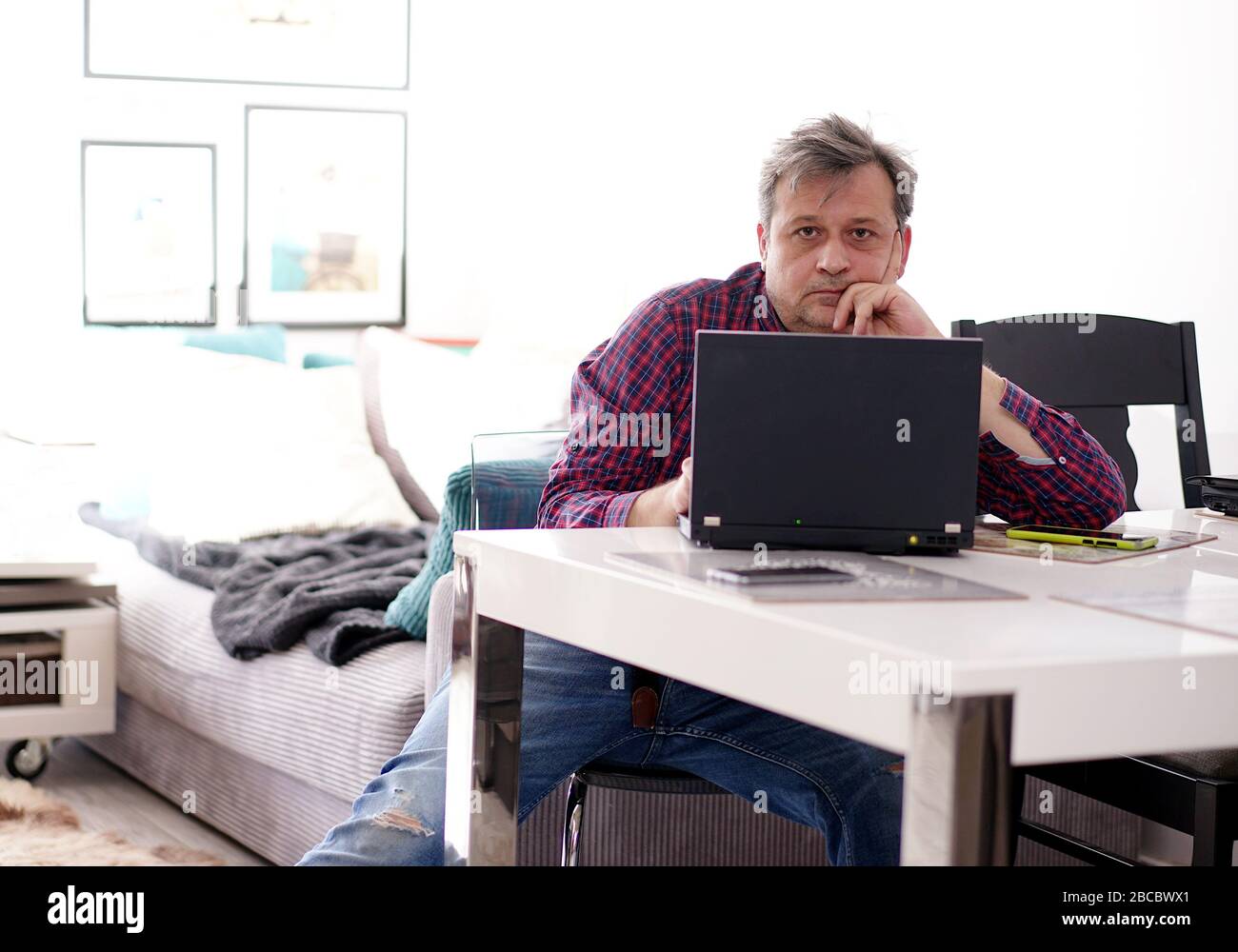 Mann mittleren Alters, der im Heimbüro Remote arbeitet Stockfoto