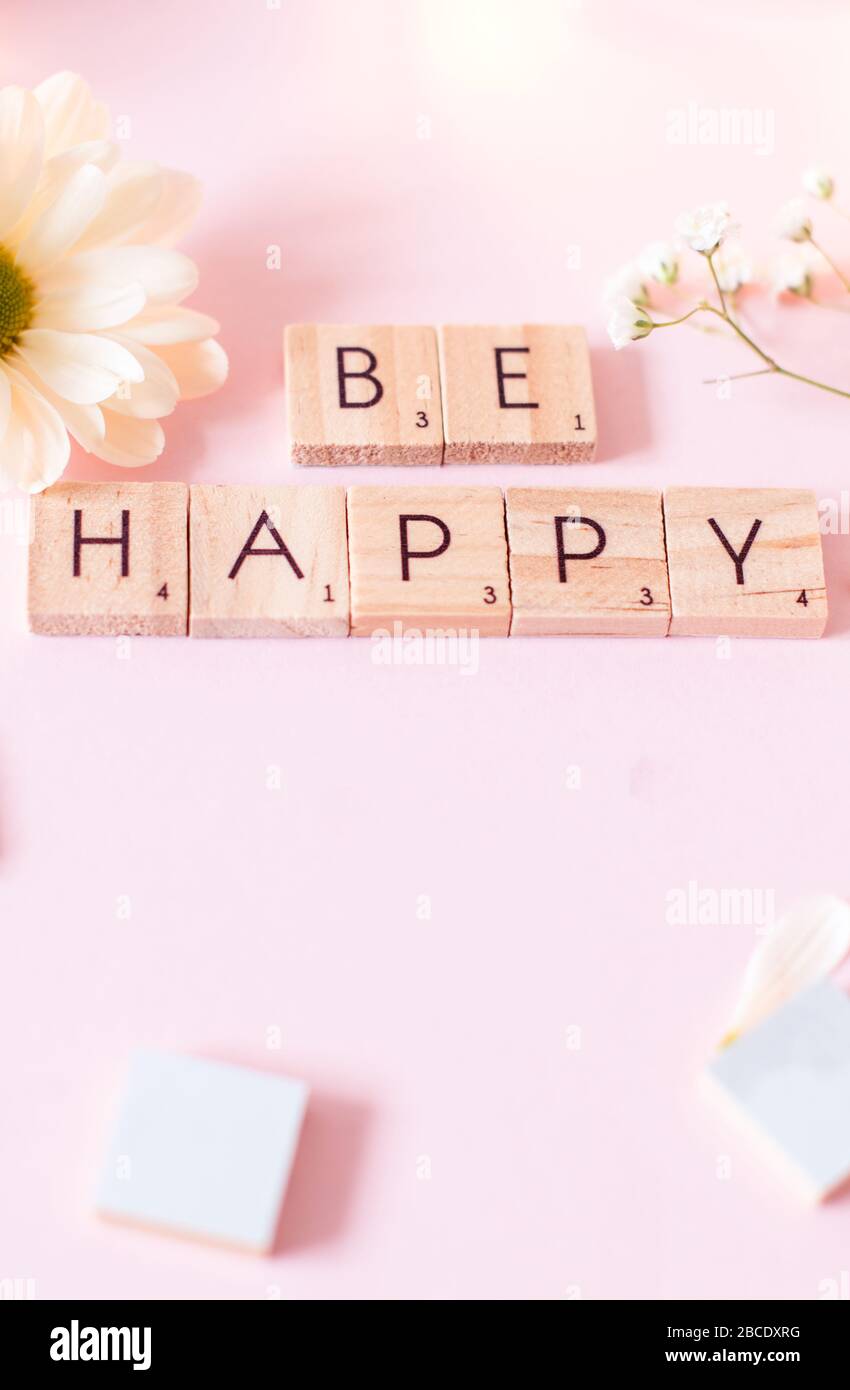 "Freut mich"-Zitat - "Stillleben"-Konzeptbild von Wörtern auf Holzfliesen vor einem weichen, rosafarbenen Hintergrund mit Kopierraum. Stockfoto