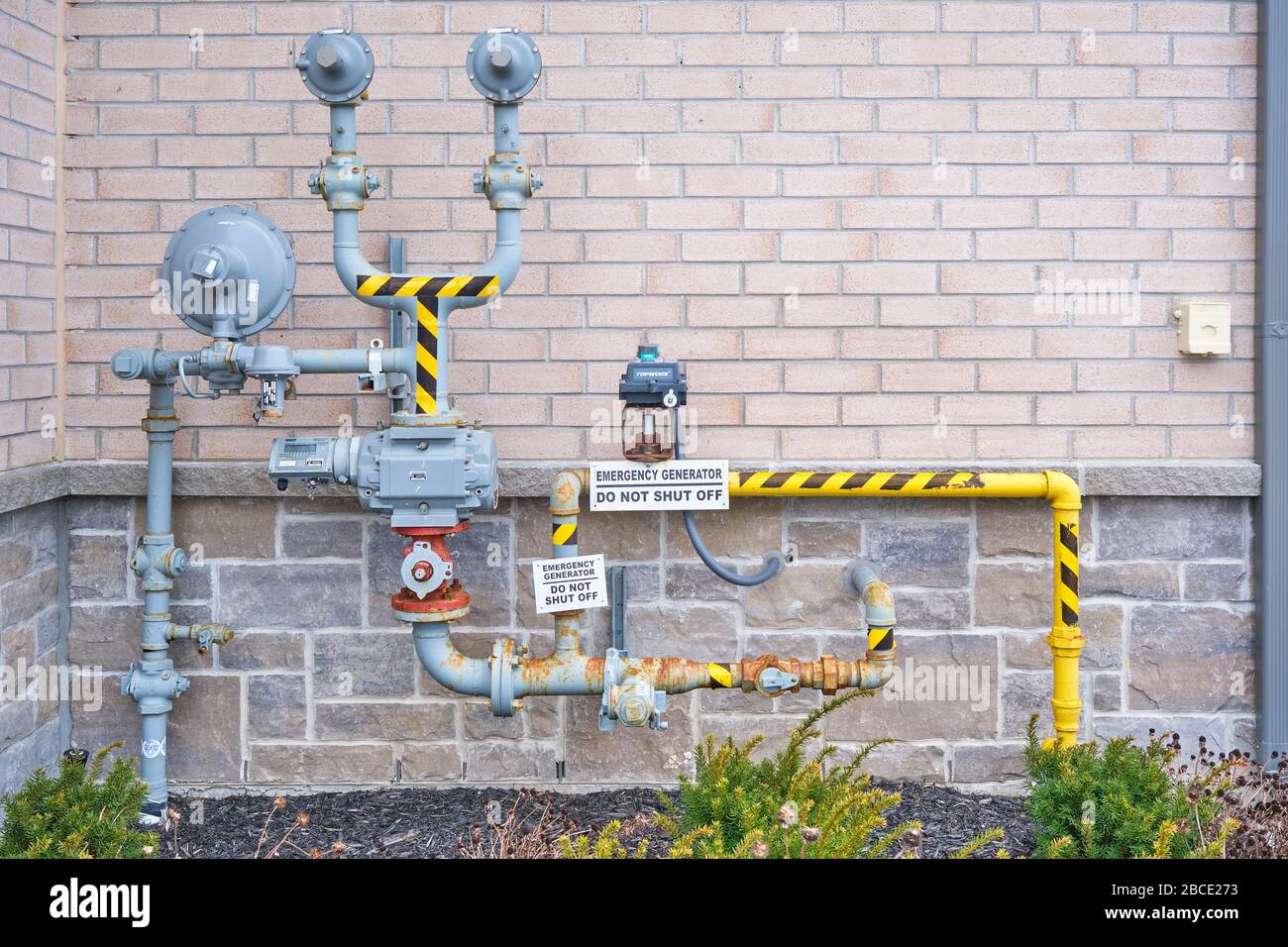 Gasregler und Ventile, die außerhalb eines Industriegebäudes installiert sind. Stockfoto