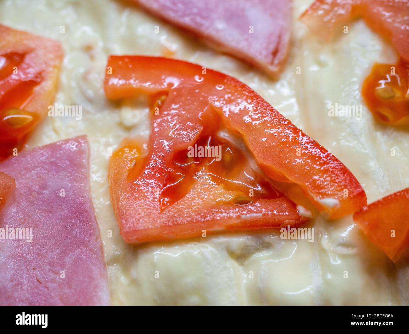 Nahaufnahme von Scheiben Schinken und Tomaten auf Gebäck Stockfoto