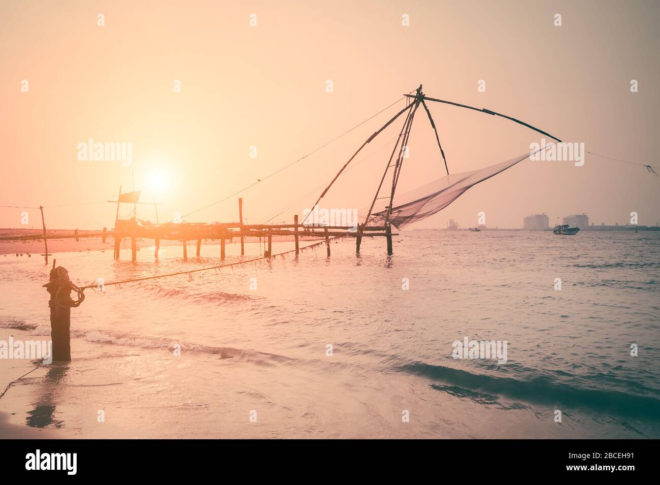 Sonnenuntergang am tropischen Strand. Meeresküstenlandschaft mit chinesischer Fischernettsilhouette in Cochin (Kochi). Südindien, Kerala, Kochin Stockfoto