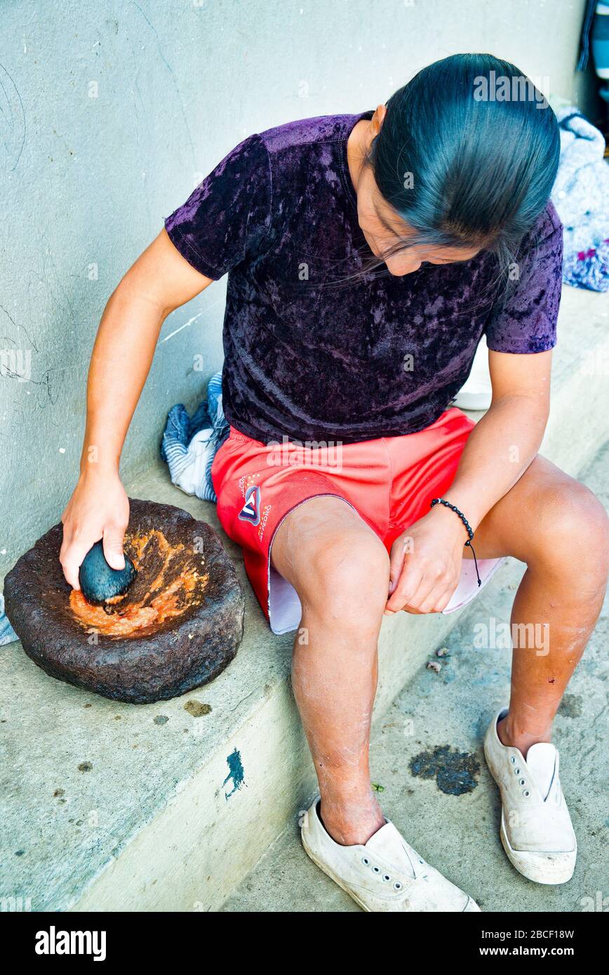 Coronavirus Aktivitäten 2of6: Schleifen von Aji-Sauce heiß und würzig mit Steinmörtel und Pfanne in San Pedro Gemeinschaft, Cotacachi Ecuador Stockfoto