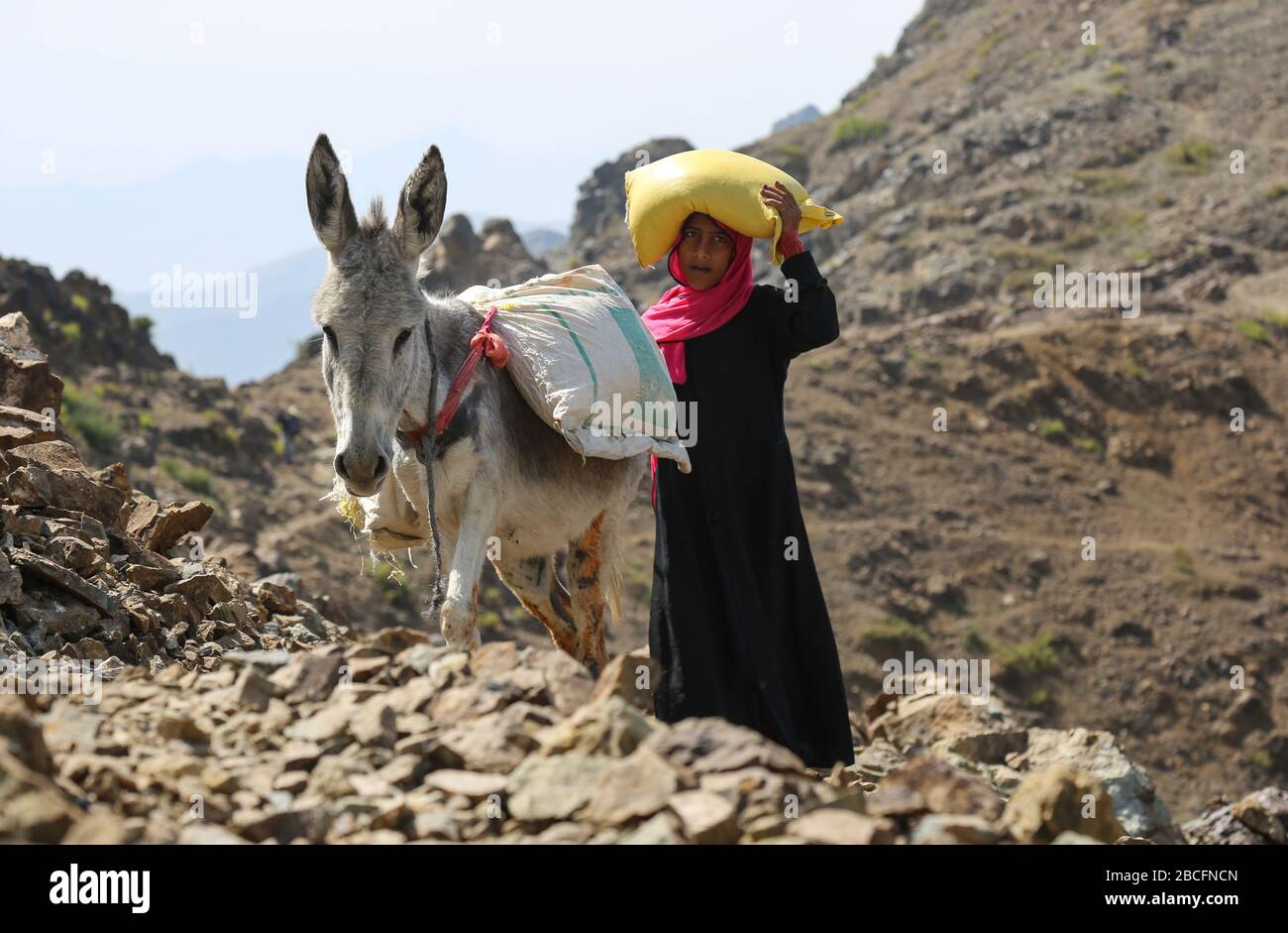 Taiz / Jemen - 02 Apr 2017: Jemenitische Kinder bringen auf holprigen Bergstraßen Essen und Trinken mit, weil die Stadt Taiz belagert und Krieg geführt wurde Stockfoto