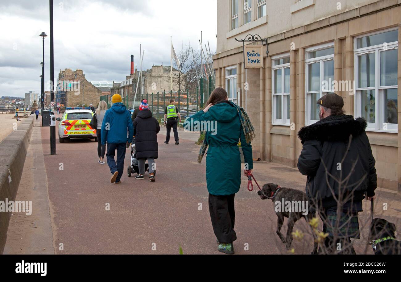 Portobello Beach and Promenade, Edinburgh, Schottland, Großbritannien. April 2020. Am Nachmittag bewölkt 10 Grad mit ruhigem Strand, aber manchmal sehr belebte Promenade, verursacht durch Radfahrer, die sich aufballen und Fußgänger durchweben. Auch zum ersten Mal gab es in den letzten zwei Wochen während Coronavirus Lockdown zu dieser Tageszeit eine Polizeipräsenz, obwohl Routine, vielleicht in Erwartung des besseren Wetters, das morgen erwartet wird, wenn heißere Temperaturen prognostiziert werden. Stockfoto