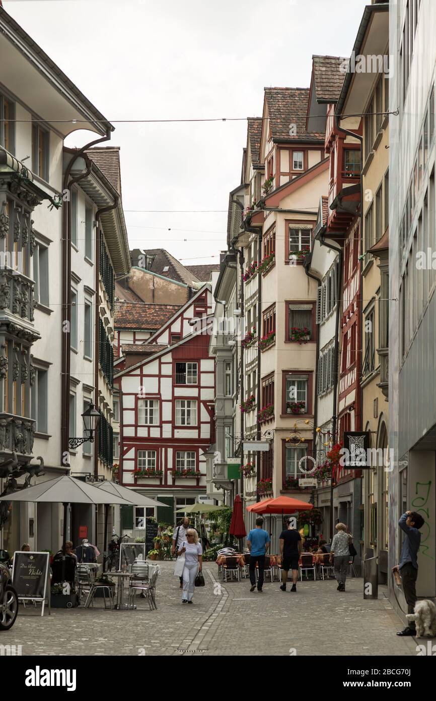 Fußgänger schlendern an urigen Geschäften und Restaurants in der Altstadt von St. Gallen, Schweiz vorbei. Stockfoto