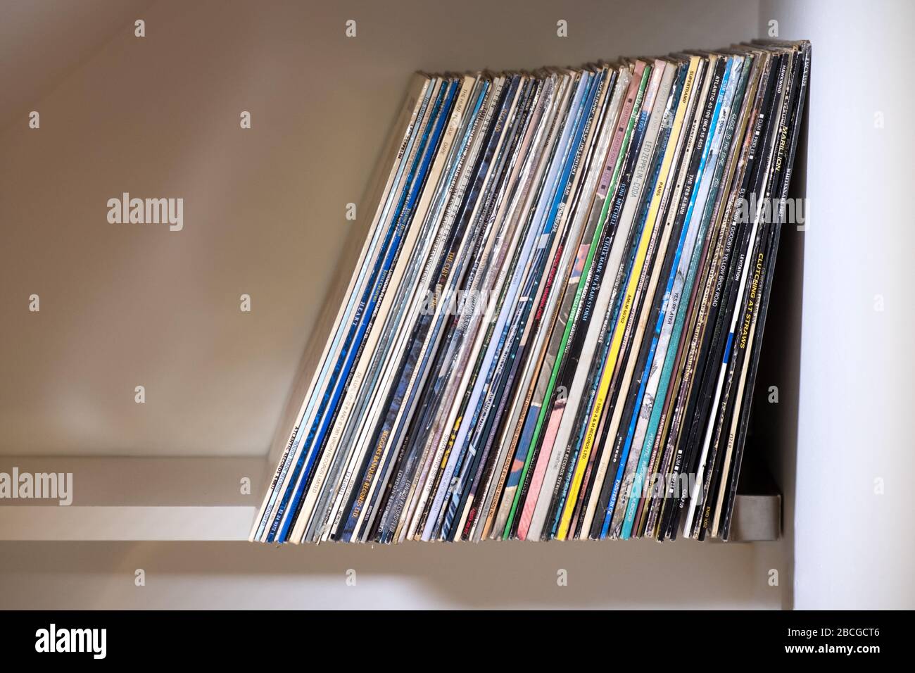 Eine Reihe von Plattenalben oder Vinyl-Schallplatten, die aufrecht auf einem Regal gelagert werden Stockfoto
