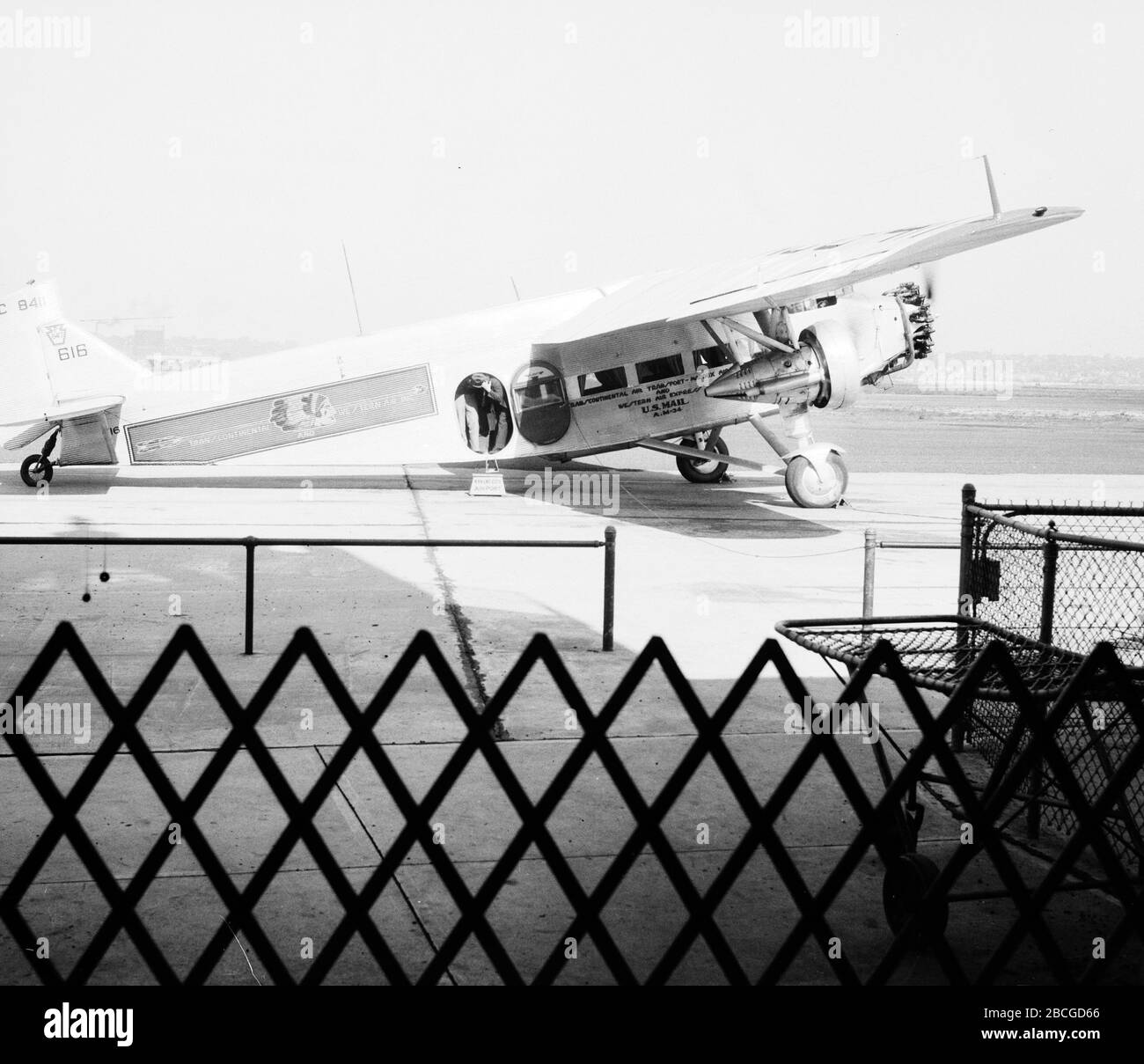 Ein männlicher Passagier beginnt, ein Flugzeug der Transcontinental und Western Air U.S. Air Mail bei der Ankunft am Kansas City Airport, Kansas City, Missouri, 1934 abzufliegen. Fotografie von Burton Holmes. Stockfoto