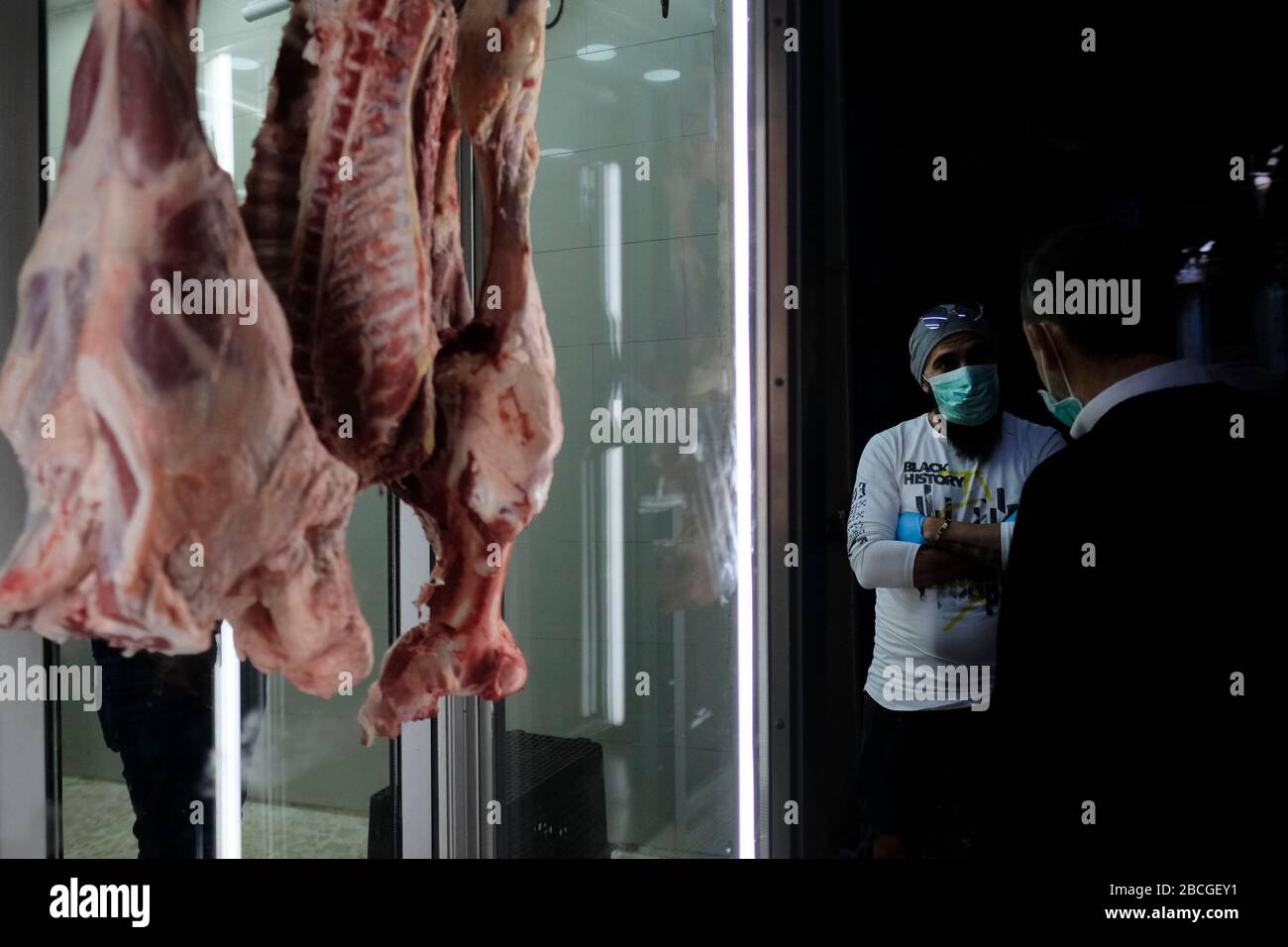 Palästinenser, die wegen der COVID-19-Pandemie des Coronavirus Gesichtsmaske tragen, stehen neben einer Metzgerei in Beit Habad, auch an der Khan az Zait Straße in der Altstadt des Muslimischen Viertels, Ostjerusalem Israel Stockfoto