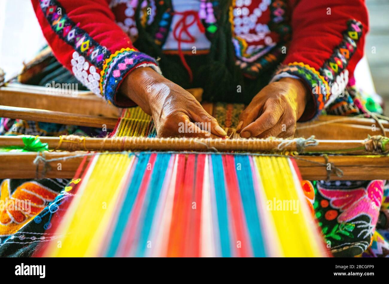 Peruanische Indigena-Quechua-Frau, die ein Textil mit den traditionellen Techniken in Cusco, Peru, webt. Stockfoto