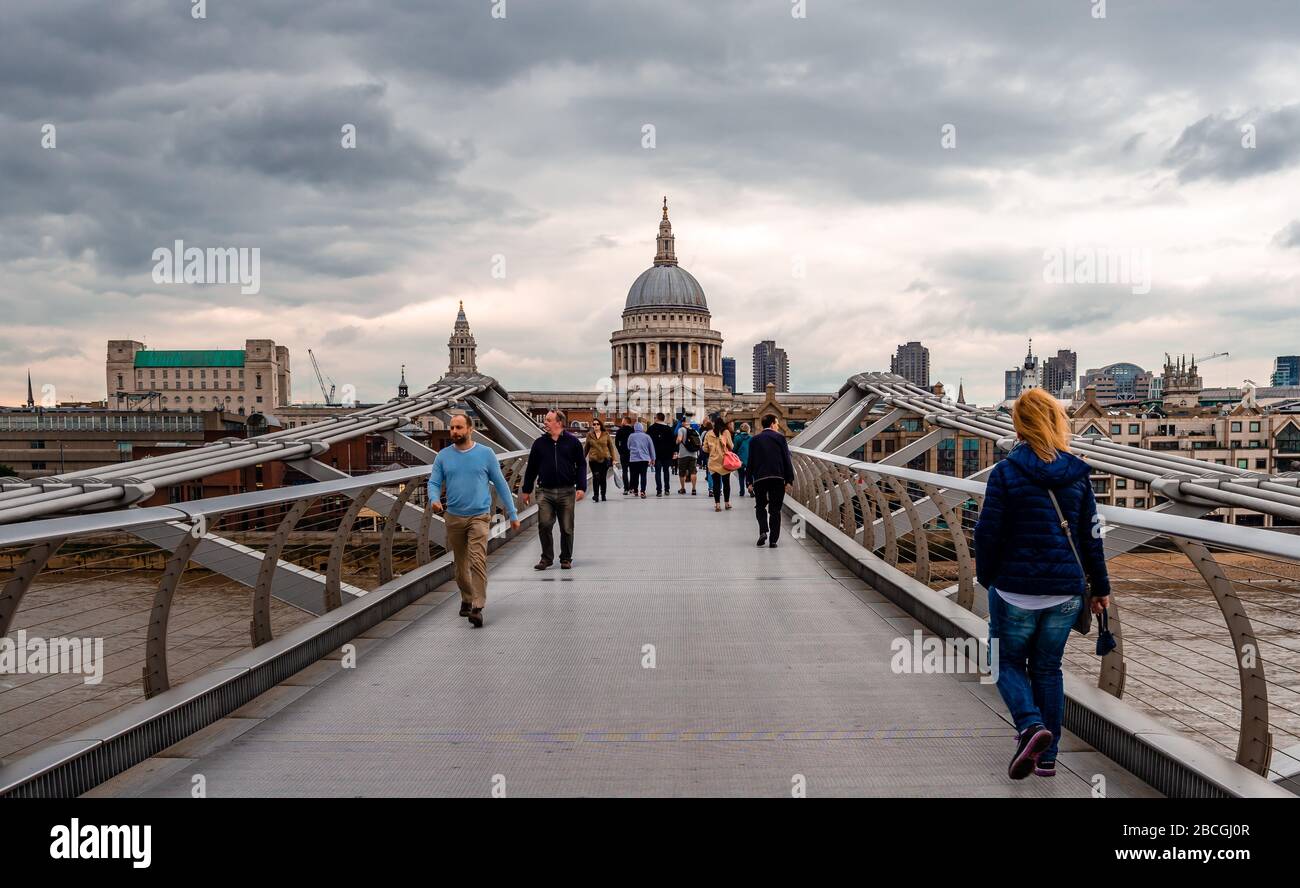 London, Großbritannien - 4. September 2015: Menschen gehen auf der Millennium (alias Wobbly) Brücke, mit der St Paul's Cathedral im Hintergrund. Stockfoto