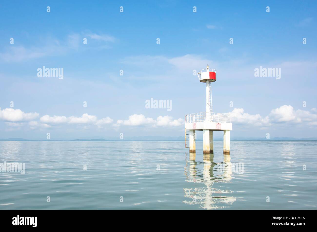 Der Leuchtturm im Meer mit Abflugung von Wasserhintergrundwolke und Himmel. Stockfoto