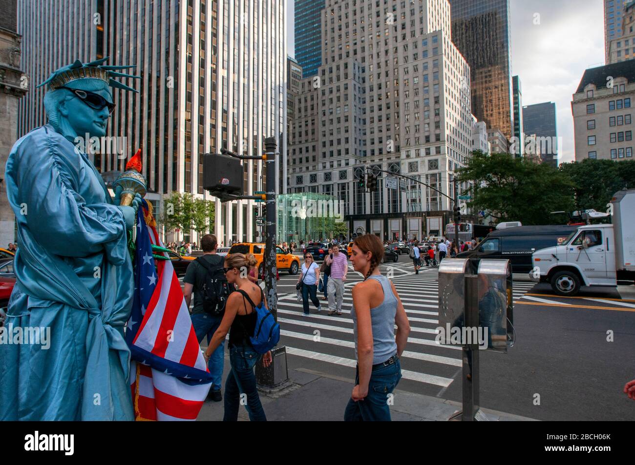 Eine in Freiheitsstatue gekleidete Menschenstatue mit Touristen, die darauf warten, am Ausgang des Central Park plaza mit Blick auf die Grand Army Plaz fotografiert zu werden Stockfoto