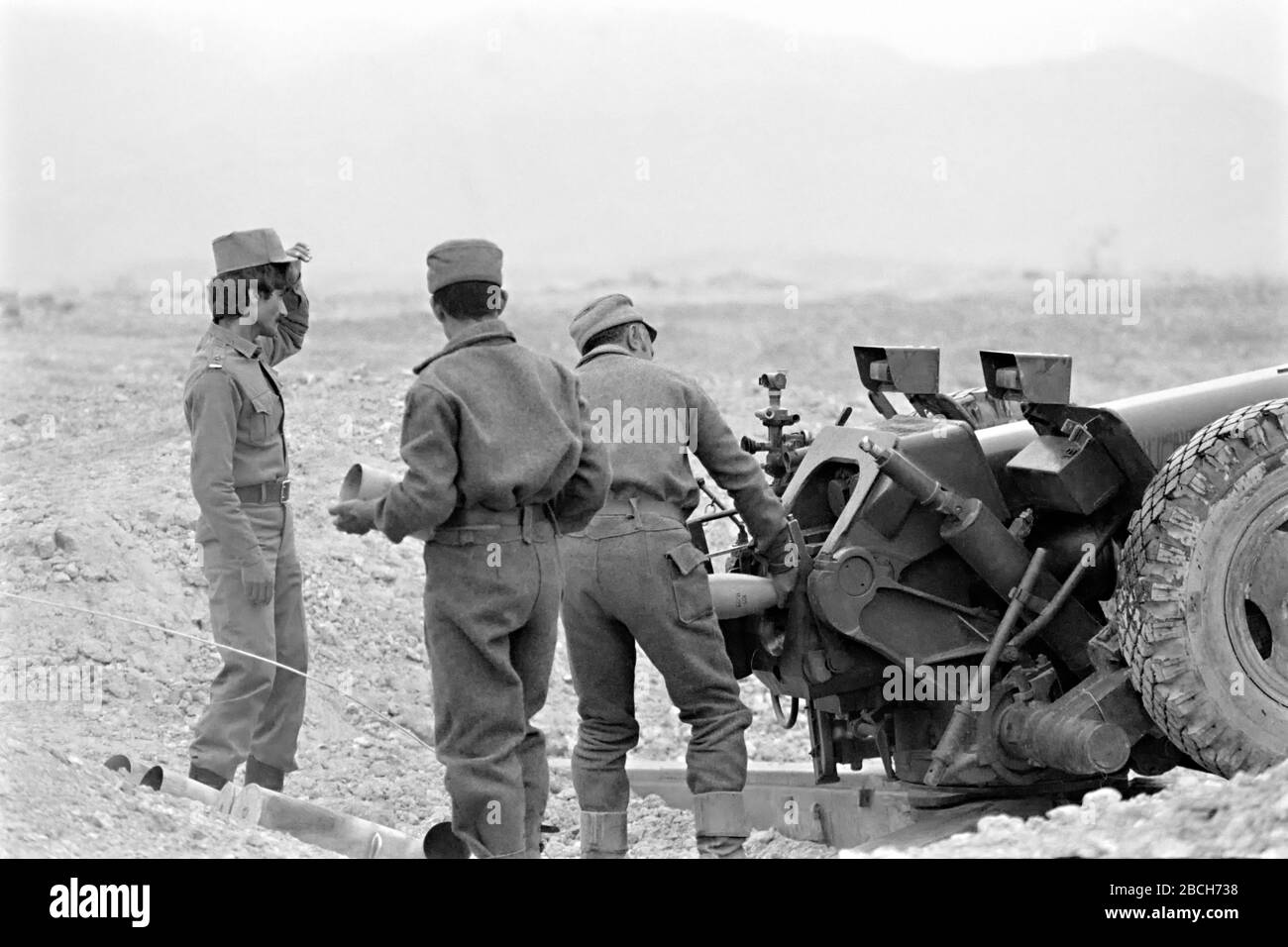 Afghanische Soldaten laden auf dem Pagaman Forward Operating Post vom 1. Mai 1989 in Pagaman, Afghanistan, in eine aus der Sowjetunion gefertigte 122-mm-Kanone. Die Basis schützt einen Haupteinstiegspunkt in die Hauptstadt Kabul und ist weniger als eine Meile von den Frontlinien der afghanischen Mudschaheddin Fighters entfernt. Stockfoto