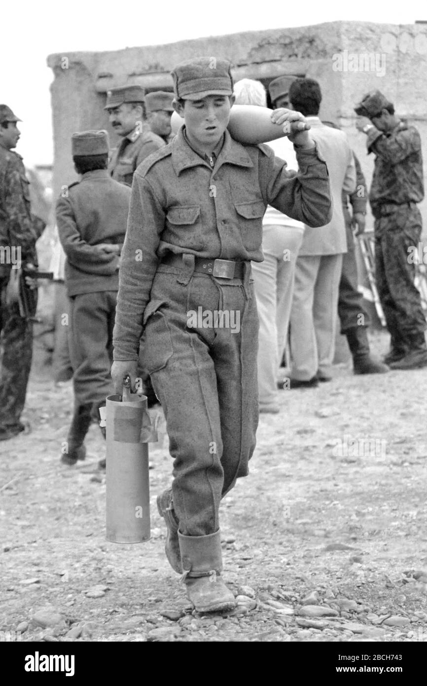 Ein afghanischer Soldat führt am 1. Mai 1989 in Pagaman, Afghanistan, auf dem Einsatzposten Pagaman Forward, für eine von der Sowjetunion hergestellte 122-mm-Kanone Artillerie-Runden. Die Basis schützt einen Haupteinstiegspunkt in die Hauptstadt Kabul und ist weniger als eine Meile von den Frontlinien der afghanischen Mudschaheddin Fighters entfernt. Stockfoto