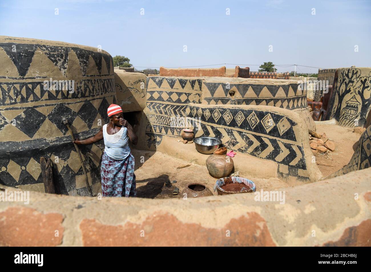 Afrika, Burkina Faso, Region Pô, Tiebele. Stadtansicht des königlichen Hofdorfes in Tiebele. Eine Frau kocht Stockfoto