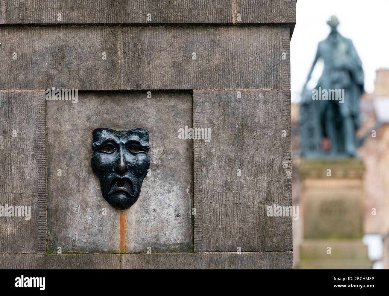 Theatralische Maske Bronzerelation mit traurigem Gesicht auf der High Street Wellhead auf der Royal Mile in Edinburgh, Schottland, Großbritannien, um auf Traurigkeit der Annullierung des Edinburgh Fringe Festivals 2020 hinzuweisen. Stockfoto